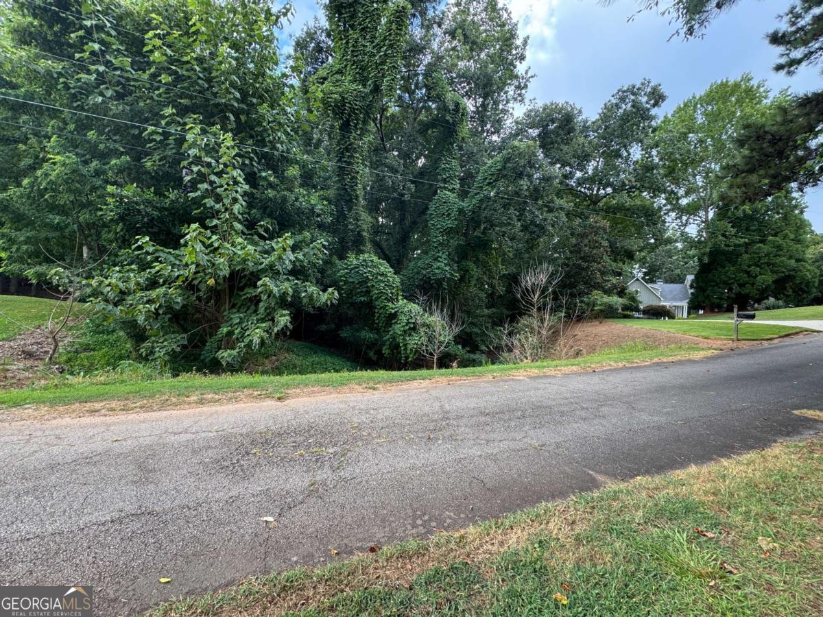 0.23-acre wooded lot located on a short, quiet cul-de-sac street that ends at Lake Lanier. The street features beautiful homes, some with lake views or dock access, and is situated near other high-end properties. This lot is surrounded by established homes in a desirable residential area with no HOA. The lot has a natural slope and a drainage path that forms during rainfall. An engineer has walked the property, and based on their assessment, rerouting the water flow was considered possible with proper grading and planning. A prior soil test indicated suitability for a septic system. Power and road access are available. The property is raw and undeveloped, and the price reflects the need for septic installation, and general site preparation. *Seller is motivated and open to reasonable offers. Buyer to perform their own due diligence regarding all development feasibility, permits and utility access.