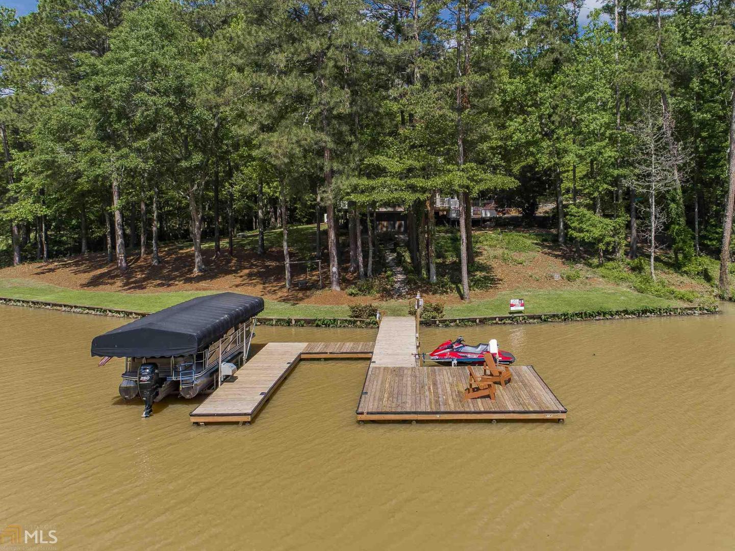 Beautiful lake front home on Oconee with in-ground pool, large sun deck, and wrap around covered porch in the sought-after Sebastian Cove community. This cozy 5 bedroom home is ideally positioned for privacy with a heavily wooded lot. The dock is positioned just off the main lake for wave protection but offers open lake views. Well maintained home that has been upgraded with newer flooring, baths, granite tops, and more. Deep water at the max dock, boat lift, and room for all of the toys with 220' of shoreline. Great location, great price, and move in ready! Gentle slope to the dock and fairly level back yard make for an ideal hope and lot to entertain friends and family.