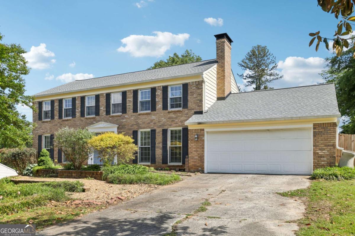 Charming Colonial with Spacious Living, Unique Features & Private Backyard Oasis! This beautiful home offers generous living spaces, unique architectural details, and modern updates throughout. Step inside to find wood floors flowing through the main level living areas including formal living/dining room, perfect for entertaining or flexible use. The dedicated office with French doors provides a quiet space to work from home. The inviting family room features abundant natural light, a beamed ceiling, and a stunning full-length brick fireplaceCoperfect for cozy gatherings. The eat-in kitchen features stainless steel appliances, a pantry with rustic barn doors, and a convenient pass-through window to the screened-in porch, creating a seamless indoor/outdoor living experience. Enjoy year-round bug-free living in the spacious screened-in porch, ideal for relaxing or dining al fresco. A large laundry room and half bath complete the main level. Upstairs, retreat to the primary suite with charming built-in bookshelves and a luxurious en-suite bath featuring granite counters, vanity seating, a soaking tub, a fully tiled walk-in shower, and a walk-in closet. Three additional spacious bedrooms share a well-appointed full hall bath, offering plenty of space for everyone. Looking for more room to grow? The unfinished basement offers endless possibilities, with framed areas ready to be transformed into a home office, gym, playroom, media room, or craft space. Outside, enjoy the huge fully fenced backyard that backs to serene woods for added privacy. Entertain on the elevated deck or unwind on the separate stone patioCoperfect for cool Georgia evenings. Updates include new exterior paint, gutters, leaf guards, roof, HVAC, tankless water heater, landscaping, fencing and more! Community features pool, tennis, pond, walking trails, and more!