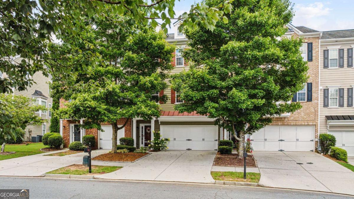 Welcome home to peace and serenity in the heart of Suwanee! Discover one of the largest and most desirable floor plans in the sought-after Suwanee Station community. This beautifully maintained, move-in-ready townhome offers the rare luxury of a private backyard oasis-yes, actual yard space in a townhome! Step inside to find a spacious entry-level guest suite complete with a full bath and direct access to the serene backyard, perfect for relaxing on the porch swing and enjoying the peaceful sounds of nature. As you make your way upstairs, you will be welcomed by a bright and airy open-concept living space, where natural light fills the room from every angle. The expansive kitchen flows effortlessly into a casual dining area and offers direct access to the back deck-perfect for taking in tranquil views and peaceful surroundings. The top level features two expansive bedrooms, each designed as a private owner's suite, both with walk-in closets and ample space for comfort and relaxation. Just a few features of this home include: all new windows installed in 2019, a new roof installed in 2024, fresh interior and exterior paint, and the washer and dryer is included. The HVAC has a Captura germicidal UV system which provides several benefits, including improved air quality, enhanced system efficiency, and potential cost savings. Enjoy the convenience of a front-level entry garage with additional storage space, making parking a breeze for you and your guests. This home has convenient access to all of the resort style amenities that Suwanee Station offers including an Olympic-sized pool, multiple tennis and pickleball courts, clubhouse, walking trails, and more. They say location is everything-and Suwanee Station delivers. Just minutes away, you will find Suwanee Town Center, where timeless small-town charm meets the lively energy of local dining, boutique shopping, community events, and concerts-all with easy access to the scenic greenway and walking trails. This is the one you have been waiting for!