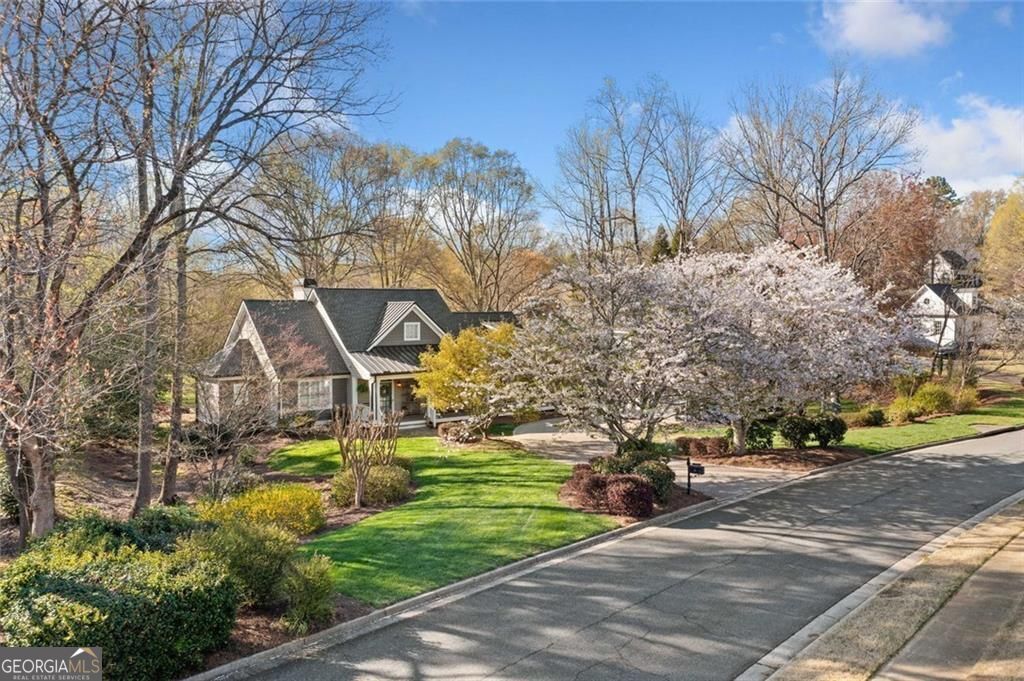 This move-in ready Ranch in Bradshaw Farm brings together updated interiors, a full in-law suite, nearly an acre of land bordered by two creeks providing unmatched privacy, and a location that puts golf, pools, tennis, and more just a short walk or cart ride away. With a newer roof, new HVAC, 2 water heaters, tankless and a brand new 50 gallon water heater, whole-house water filtration system, and even a FEMA-approved storm shelter, it's a rare mix of charm, function, and peace of mind. Step through the front porch into a bright, open floor plan with refinished hardwoods and updated lighting throughout. The main living space features a vaulted ceiling, built-ins, and a gas fireplace framed by a classic wood mantel. The fully renovated kitchen includes quartz countertops, shaker cabinetry, stainless steel appliances, and a custom farmhouse sink, flowing into a wet bar with natural light all around. Just off the kitchen, the screened porch and large back deck invite you to relax and listen to the creeks running along both sides of the property. The primary suite is privately situated and features a spa-inspired bathroom with a freestanding soaking tub, marble tile shower, and dual closets-one of which serves as a reinforced storm shelter. Private office or flex room just off primary suite. Two additional bedrooms and renovated Jack and Jill bath with an additional freestanding tub and separate shower featuring handmade Spanish tile complete the main level, offering flexibility for guests or workspace. Over the oversized detached garage, a full in-law suite adds a fourth bedroom or living area, kitchen, and bath with a separate entrance-ideal for visitors or extended stays. Outdoors, the flat, landscaped yard offers space to play, garden, or entertain. In Bradshaw Farm, you'll also enjoy access to golf, multiple pools, tennis courts, pickleball, volleyball, basketball, a clubhouse, and playground-all in one of Woodstock's most sought-after neighborhoods.