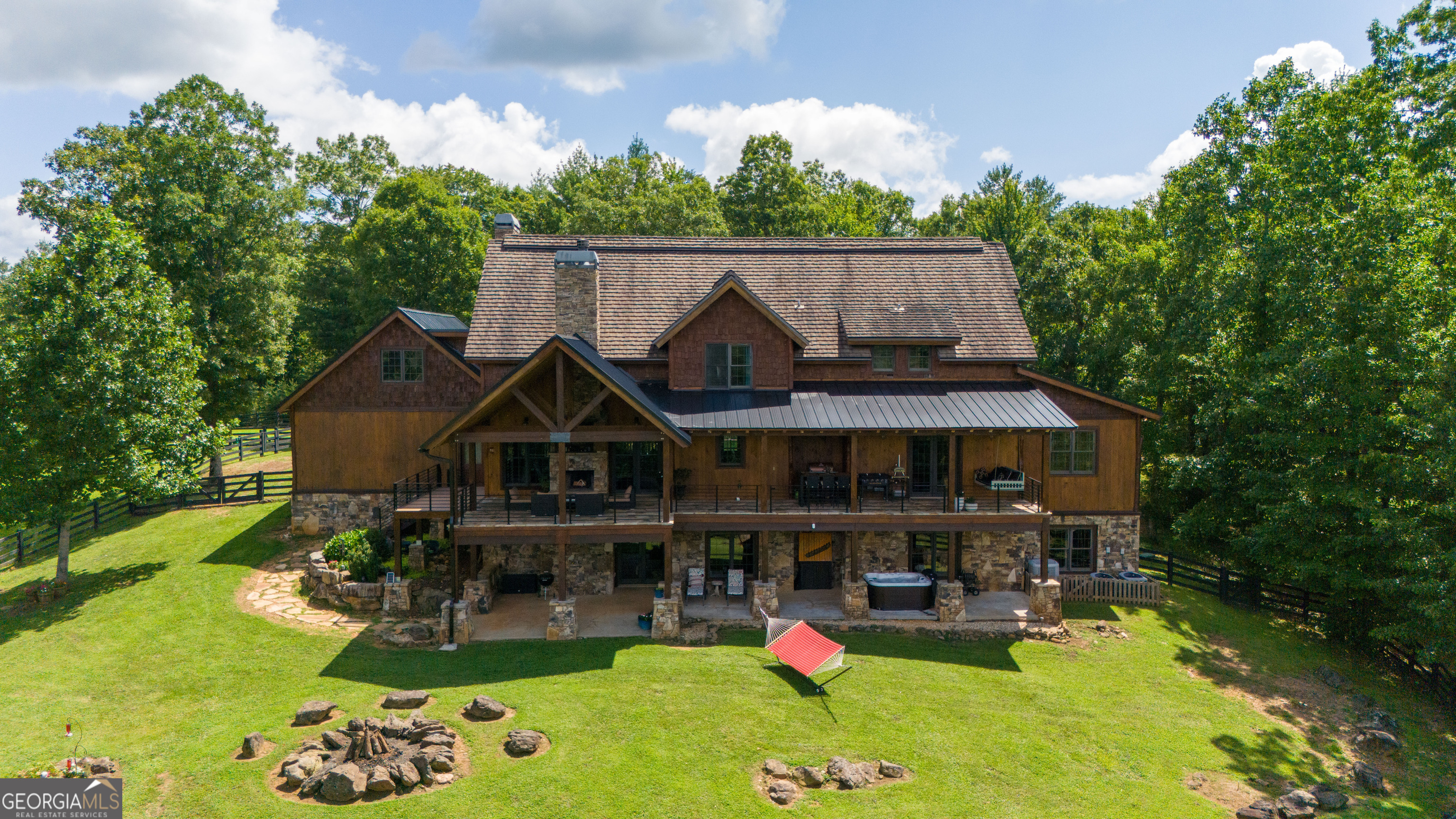 Don't miss this incredible opportunity to own the ultimate mountain retreat at 98 S Saddleback Trail, Blue Ridge, GA! This magnificent 6,975 sq. ft. estate boasts 4 king master suites, each with ensuite baths featuring luxurious tile showers, oversized soaking tubs, custom walk-in closets, and serene sitting areas. Plus, a versatile bunk room or playroom adds to the home's charm. Enjoy cozy evenings by one of the three wood-burning fireplaces with gas starters or unwind in the brand-new Dimension One hot tub. The house is equipped with modern conveniences, including a whole-house Generac backup generator, two tankless hot water heaters, and a whole-house water filtration system. High-speed fiber optic internet upgraded to 1000 Mbps ensures you're always connected, with a point-to-point system extending Wi-Fi to the barn and the 1,500 sq. ft. storage building/workshop. The four-level home sits on a sprawling 9.38 acres with two healthy pastures perfect for animals, year-round grass, and cross-fencing. Additional highlights include a two-car garage, gated entry, all-paved roads, and a past successful STR history. The property offers stunning long-range mountain views, hardwood, and tile flooring throughout, and a partially finished 2,790 sq. ft. basement with plumbing, HVAC, and electrical ready for your finishing touches. Embrace the mountain lifestyle with everything you need for comfort, luxury, and outdoor enjoyment! Also available for purchase with 150 Cadence Way, an expansive 403-acre estate featuring another luxurious home, a 19,200 sq. ft. barn, and a 22,400 sq. ft. covered arena. A rare opportunity to own your dream mountain escape! This listing is available for optional purchase alongside property GAMLS# 10206088, creating a combined 413-acre estate. Included is a 4,659-square-foot home built in 2008, featuring 4 bedrooms and 3.5 bathrooms. The property also boasts a 22,400-square-foot fully covered arena with 19 horse stalls, a foaling stall, a farrier stall, 2 wash bays, a veterinarian room, a tool room, a tack room, a full industrial kitchen, a two-bedroom apartment, 6 baths, a viewing room, 2 laundry rooms, a main floor lobby atrium, and two offices. Additional buildings include an 8,750-square-foot storage barn and a 2,600-square-foot utility shed. The possibilities are endless-whether as an investment with development potential, a grand estate for North Georgia living, or a family getaway for weekends and holidays. This is a must-see property! Video tour: https://www.canva.com/design/DAGOTXihzEw/slD_HKOSqU7g8ew3yt6fxQ/watch?utm_content=DAGOTXihzEw&utm_campaign=designshare&utm_medium=link&utm_source=editor
