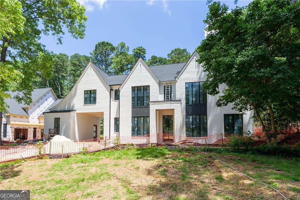 Experience elevated living in this luxury new construction home, perfectly positioned in the heart of Alpharetta's "Garden District" This spectacular residence features 5 bedrooms, 5.5 bathrooms, a 3-car garage, porte cochere, and a sought-after owner's suite on the main level-an ideal layout for sophisticated living. A covered front entry with gas lanterns opens to a dramatic two-story foyer. Inside, 12-foot ceilings and hardwood floors flow throughout the main level. A private office and powder room sit just off the entry. The main-level owner's suite features vaulted ceilings, a spa-like bath with a freestanding tub, frameless glass shower, dual vanities, and a spacious wardrobe closet. The gourmet kitchen boasts top-tier appliances, a large island, custom range hood, and a separate catering kitchen/pantry. A breakfast room flows into the family room, complete with a fireplace and built-in shelving. Just off the kitchen, a mudroom includes custom lockers and hooks for daily convenience. Upstairs you'll find a generous loft, a second owner's suite with dual walk-in closets and a beautifully finished bath, plus three additional en-suite bedrooms with walk-in closets. A full laundry room is also located upstairs. Enjoy year-round outdoor living with a covered fireside lounge and space planned for a FUTURE POOL. All this just steps from the shops, restaurants, and energy of Downtown Alpharetta-walkable to weekend events, music, and local charm.