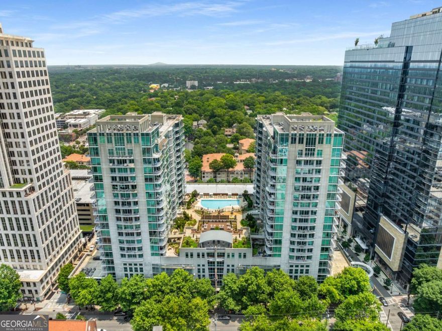 Experience the best of vibrant Midtown living in this sophisticated, modern top-floor 2-bedroom condo perched in one of Atlanta's most desirable high-rise communities. With 12 ft floor-to-ceiling windows and a private balcony, this unit gets plenty of natural light and offers stunning skyline views of Piedmont Park that bring the city to your doorstep. Custom tile throughout and stylish modern finishes that define this urban elegance. The sleek kitchen features under-cabinet lighting, contemporary cabinetry, stainless steel appliances, and a breakfast bar.  The primary bedroom offers a quiet retreat with a walk-in, cedar-lined custom closet designed for both form and function. A generous hall bathroom features modern fixtures and thoughtful design with a jetted, soaking tub with multi-point shower system encased in custom tile work, while the second bedroom-currently configured as an open-air den-can easily be converted back for guests, a roommate, or a private home office. You'll also enjoy the convenience of in-unit laundry and included parking on the lowest floor.  This full-service building offers a curated suite of resort-style amenities to elevate daily living. Enjoy 24-hour concierge service, a saltwater pool with sun deck, a state-of-the-art fitness center, multiple grilling stations, fireside lounges, a dog walk, EV charging stations, and a chic clubroom complete with a catering kitchen and coffee bar. Go downstairs to enjoy Midtown's world-class dining, boutique shopping, and cultural landmarks like the Fox Theatre, High Museum of Art, and Georgia Tech, Piedmont Park, the Beltline, Whole Foods, and MARTA are all easily accessible without the use of a car. FHA approved building!