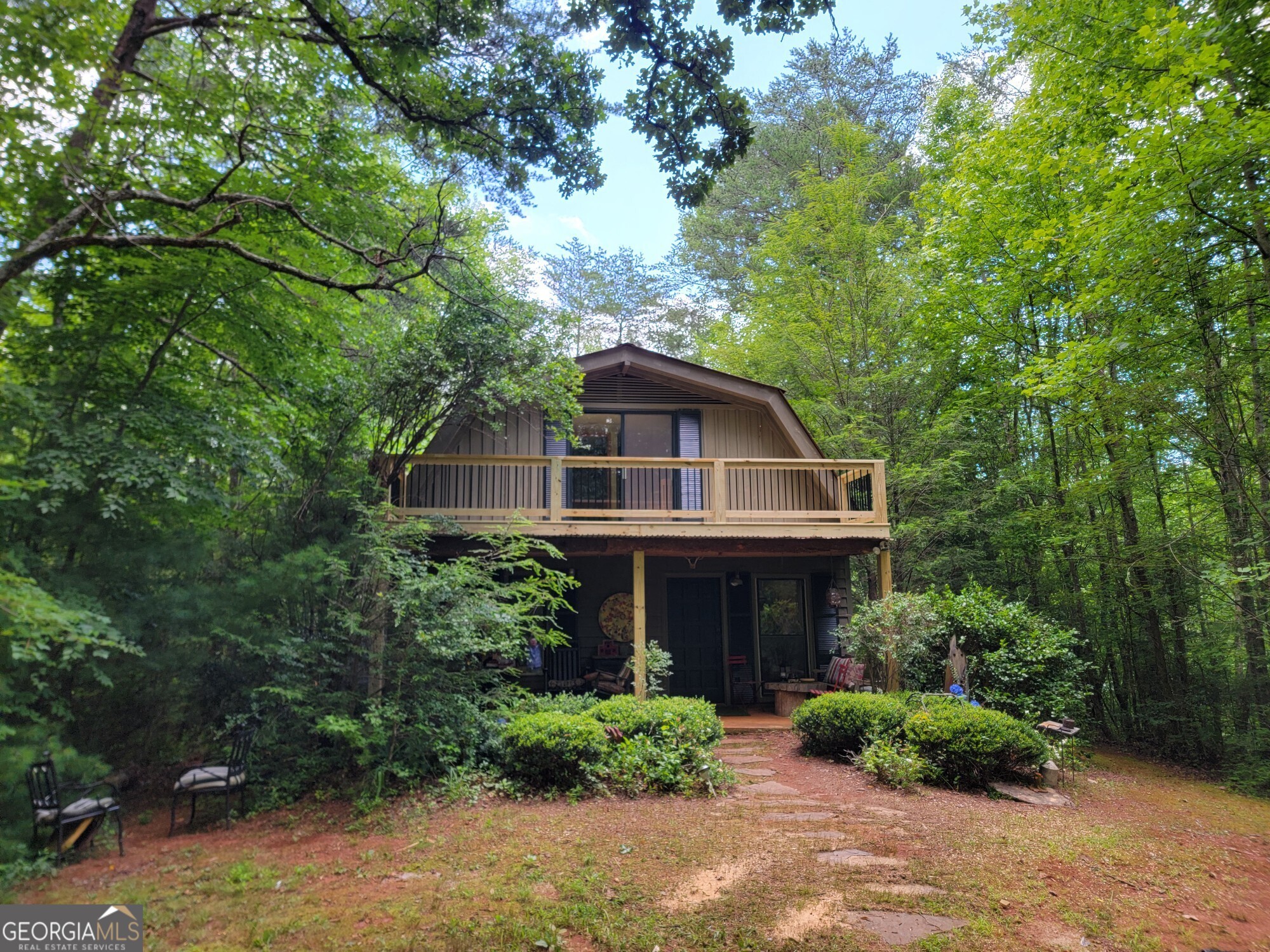 This is your opportunity to Escape to Your Mountain Sanctuary! Nestled in a serene natural setting, this enchanting cabin offers the perfect blend of rustic charm and modern comfort. Fantastic new front porch and deck! With three bedrooms, one and a half baths, and unique touches throughout, this haven is ideal for those seeking a peaceful retreat or a savvy investment opportunity. Previously a successful Airbnb, this property boasts excellent potential for rental income, making it an attractive option for those looking to diversify their portfolio. Unwind on the expansive deck, surrounded by nature's tranquility, or gather 'round the cozy fireplace for quality time with loved ones. The functional kitchen ensures everyday convenience, while the cabin's character-filled details will make you feel right at home. Whether you're seeking a primary residence, a vacation getaway, or a shrewd investment, this mountain retreat offers the ultimate blend of comfort, practicality, and natural beauty. Don't miss your chance to own this rustic gem! Sold AS IS.