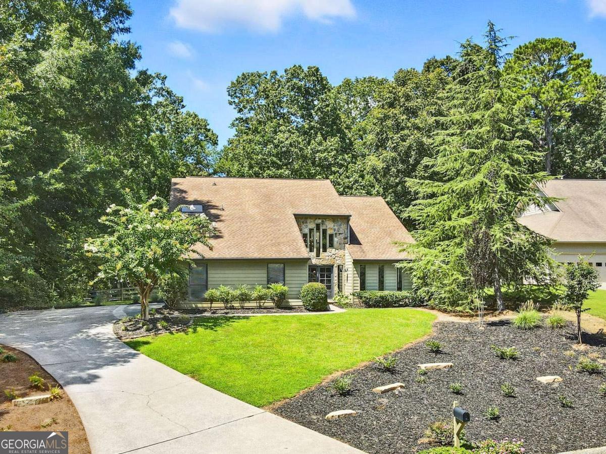 WELCOME HOME to this unique, updated 5 bedroom, 3 bath home nestled on a quiet cul-se-sac street in the highly sought-after lake community of Loch Highland in East Cobb! Award-winning Lassiter High School District! This fabulous contemporary home features thoughtfully appointed finishes throughout, vaulted ceilings, loads of natural daylight, convenient guest suite on the main level, and so much more! The main living level includes a light, bright two-story foyer, vaulted formal living room- great for a home office or flex space, formal dining room, guest bedroom, full guest bathroom, large laundry room, spacious fireside family room, and gorgeous eat-in kitchen complete with quartz countertops, premium appliances, waterfall breakfast bar, custom pantry, and adjacent breakfast area with dry bar and beverage cooler. Upstairs, you'll find 3 sizable guest bedrooms, guest bathroom, and the enormous primary bedroom with vaulted ceiling, fireplace, and spa-like ensuite bath including separate custom vanities, large walk-in double shower, separate soaking tub, and large walk-in closet! This home offers plenty of opportunity for outdoor entertaining or just relaxing on the large deck with convenient retractable awning, overlooking the rare, flat fenced-in backyard! EV Charging station in garage. The active Loch Highland community offers two swimming pools, tennis courts, lakes and walking paths, and is located near shopping, dining, entertainment, and more! Don't miss the opportunity to make this amazing home your own!