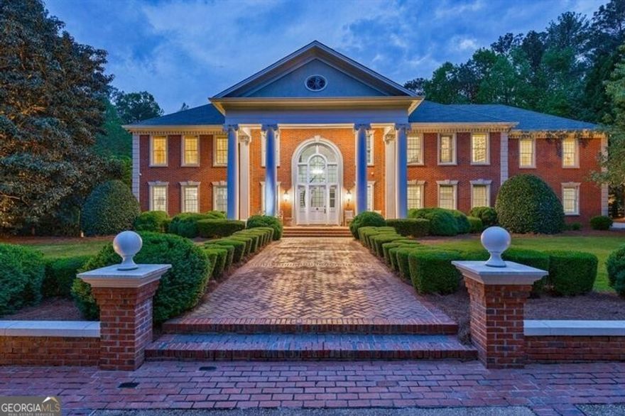 Stunning property in sought-after Cameron Crest Farms. This estate is truly one-of a kind on 5+/ acres with walking trail, pond, privacy among the trees and woods, lake front, gazebo and barn. The gated entrance leads to the tree line driveway and parking pad. Front porch opens to grand entrance foyer with stone flooring and spiral staircase. Large living room overlooks the park-like backyard. The light filled kitchen in the back of the house offers an oversized island, stone counters, stainless steel appliances and opens to the breakfast area with fireplace. The kitchen is also complete with a large walk-in pantry. Main level has formal dining room and family room off of the kitchen as well. Sought-after primary suite on main overlooks the backyard with floor to ceiling windows and is complete with a fireside sitting area. Luxurious primary suite has double vanities, separate tub and shower. Spacious walk-in closet has island and laundry area. The grand staircase leads to 5 bedrooms, 4 full bathrooms and several bonus rooms for dual offices and/or playroom. Upper level includes laundry room with sink and a hidden space above the garage that could be used as a bedroom, au-pair suite, office or man cave, it also offers a large walk-in closet and full bathroom. The grounds are absolutely breath-taking for kids, pets and entertaining. Close proximity to all that Johns Creek has to offer but the farm-like setting is so special, private and serene.