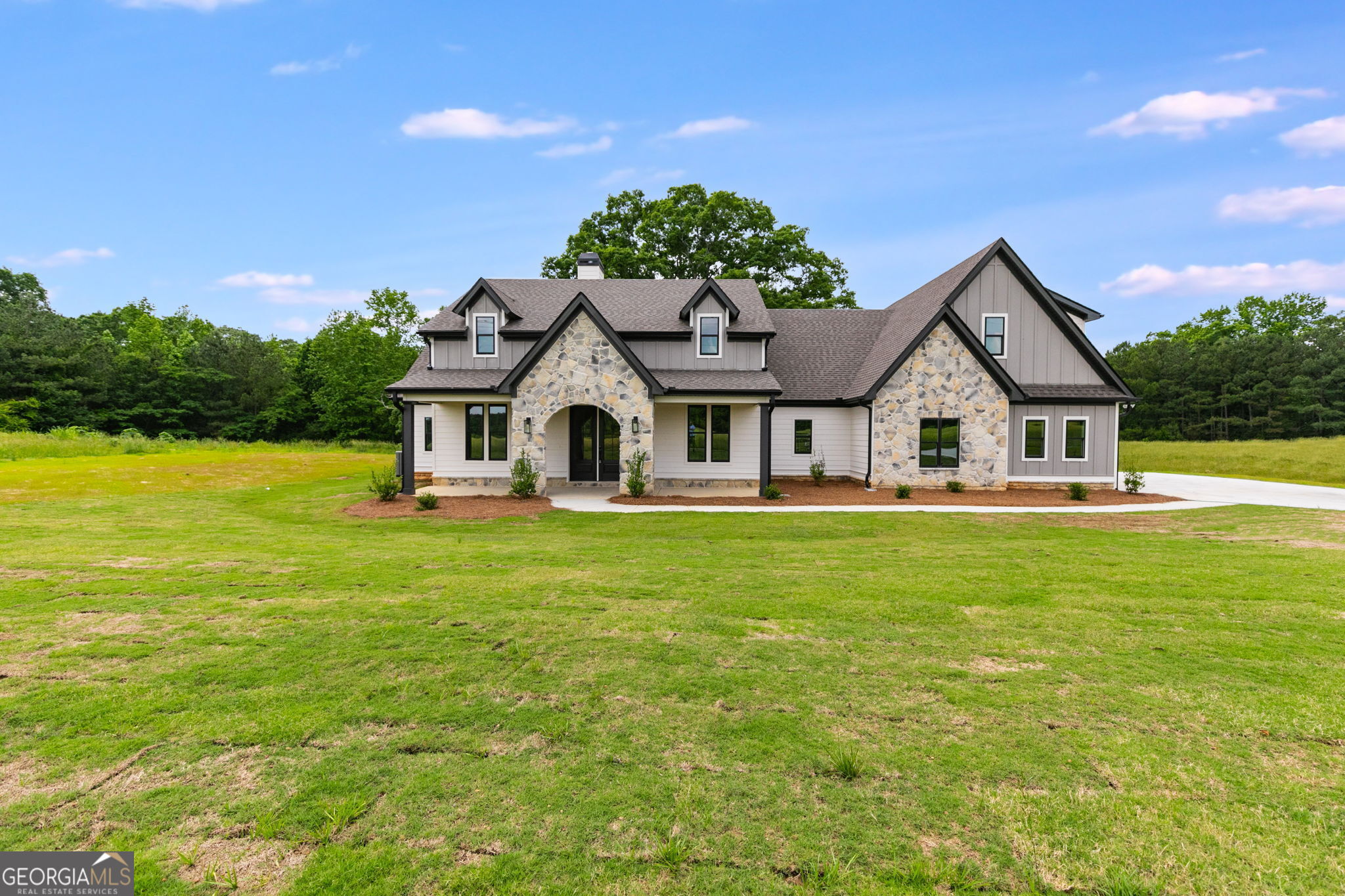 WOAH NELLIE.....HERE'S ANOTHER BEAUTIFUL HOME IN A GORGEOUS SETTING! The Meadows at Lake Circle is located in a stunning area of Haralson County known as The Flat Woods Community. It's convenient to I-20, Hwy 120, Rome, Carrollton and the surrounding smaller towns. This home has so many phenomenal features they are difficult to list. Here we go.... Owner's Suite on MAIN LEVEL, along with 3 other secondary bedrooms. There is a 5th Bedroom and full bathroom upstairs, which could also be used as an office or bonus space. When you enter the home through the wide foyer, you'll see the formal dining room to the right with high judges paneling and an elegant chandelier. The family room has a stone wood burning fireplace and has double french doors leading to the covered back patio. The kitchen is a cook's dream with Mystic Beige (cherry wood stained with a light glaze) wood cabinetry and QUARTZ countertops. The PROFESSIONAL THOR GAS COMMERCIAL RANGE is a delightful upgrade with a decorative range hood. The Owner's Suite is delightful with Fantasy Brown Granite Countertops in the bathroom, freestanding soaking tub and cool tiled shower with bench seat and lots of STYLE! This home EXUDES style and sophistication! You will not be disappointed and the finished product is sure to please. This home is equipped with a SMART HOME PKG - Zoned HVAC - Spray Foam Insulation in the attic - SUPERB WARRANTY with 10 year structural warranty. Don't sleep on this one, or it could be too late. Agent is happy to meet and go over all the Designer Selections in your personal design meeting.