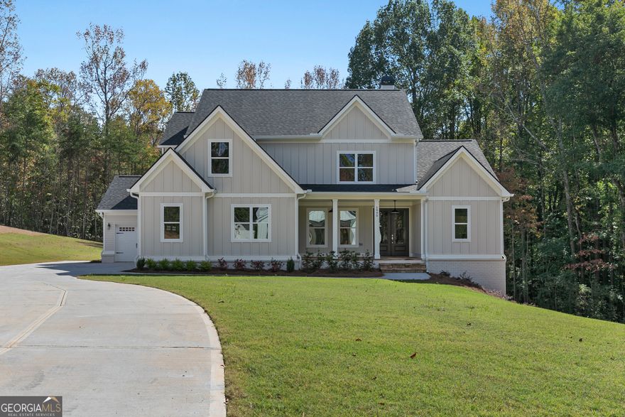 Set on 6.42 private acres near Lake Lanier, this new construction opportunity at 3 Henry Pirkle Dr. in Dawsonville offers the rare chance to design your home from the ground up. Buyers can fully customize the architecture, layout, materials, and finishes to match their vision-whether modern farmhouse or classic Southern design. The attached photos show a completed build of this plan, featuring bright open living spaces, a large chef's kitchen, elegant bath design, and an inviting covered deck with a fireplace overlooking wooded views. Conveniently located near the lake, parks, and Dawsonville shopping, this homesite combines privacy with accessibility and the freedom to create a truly personalized retreat.