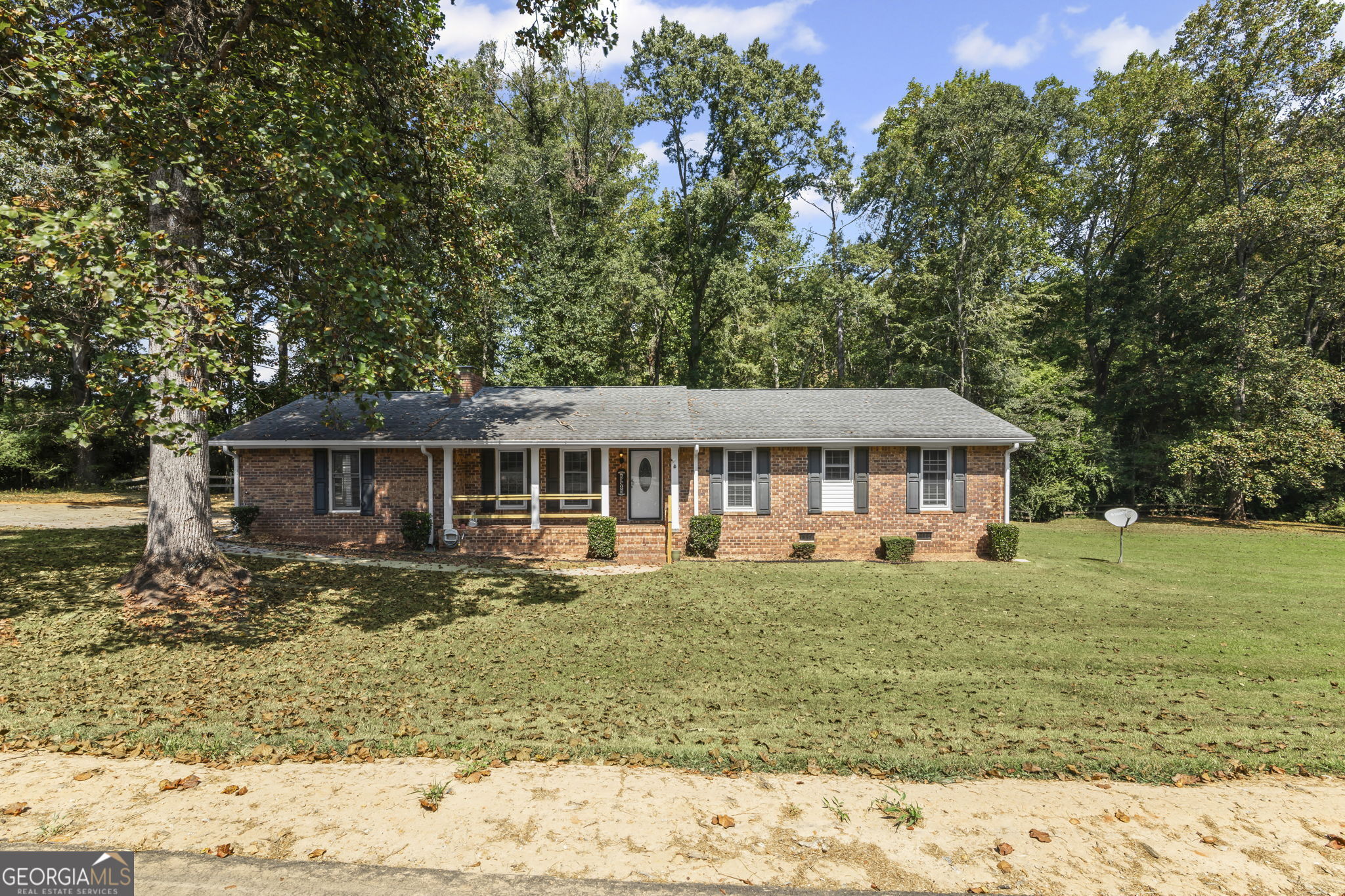 Fantastic 4 Sided Brick Ranch on almost an acre lot!!! Spacious Kitchen with all appliances remaining. Family Room with brick fireplace with wood burning insert and oak hardwood flooring!! Dining Room with oak hardwood flooring with exterior door leading out to the concrete deck! Laundry room with built-in cabinet for storage. Primary Bedroom on main with closet, ceiling fan, primary bathroom with double vanities with tiled shower/tub. Two guest bedrooms on main, both with closets and adjoining guest bathroom with LVP hardwood flooring, vanity & tiled shower. Attached double side entry carport with Kitchen level entry. Huge yard with granite firepit and built-in swing with great privacy. Minutes from bypass, I-85 and Historic Downtown Newnan!!!