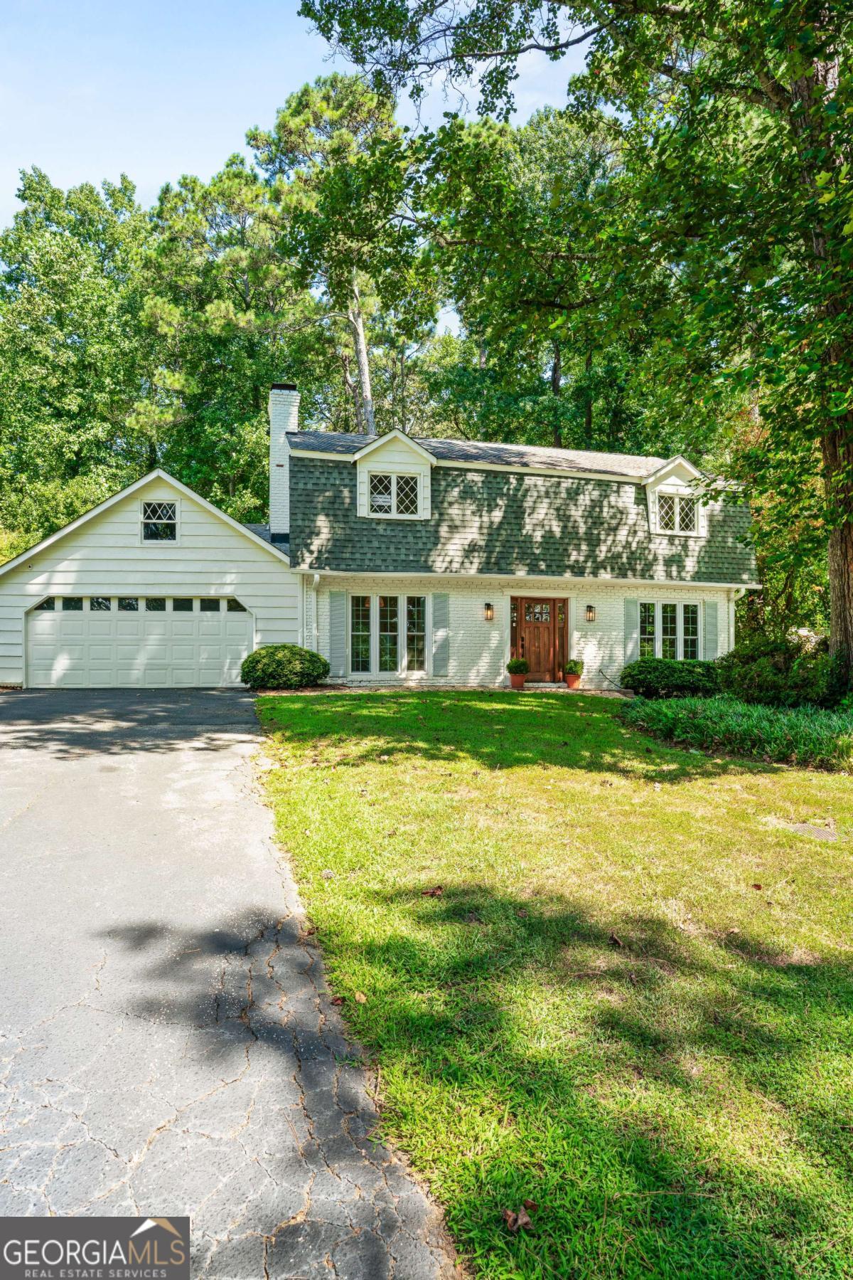 Welcome to this professionally architected and immaculately redesigned house in the heart of East Cobb offering the best rated school district of Sope Creek, Dickerson and Walton. This modernized Dutch colonial home boasts 4 bedrooms, 2.5 baths and an entirely open floor plan, with custom mill work and thoughtfully curated details showcased throughout, with function and design at the forefront of every room. Enter through the custom mahogany front door where you're immediately greeted by the star of the show, the gleaming WIDE PLANK white oak wire brushed Anderson Tuftex hardwood flooring laid throughout the entire home. A recently renovated chefs kitchen with super white quartzite, a waterfall countertop and bar seating, Viking stainless steel appliances, soft closing shaker cabinets, a custom built in banquette breakfast nook and massive glass paned triple French door system that opens directly out onto the flat backyard featuring a hot tub AND in-ground swimming pool! Plenty of space for the entire family to cozy up with living rooms on either side of the kitchen that boast tons of natural light pouring in through all new windows! You'll find custom arched built in shelving units on either side of a brick fireplace. Renovated cabinetry and countertops in each of the 3 bathrooms with taj mahal quartzite stone countertops, hardware, plumbing, efficient toilets and new fixtures throughout. A Stunning two story hallway leads to the upper level with a custom built in office nook and bookshelves, perfect for school work!! Make your way to a spacious primary bedroom and ensuite and three additional bedrooms all on the same level. From top to bottom everything in the house is new or revitalized!! Fresh interior and exterior paint. Replaced electrical, plumbing, nest thermostat, light fixtures, outlets, switches, hardware, French drains, 2020 hot water heater and NEW HVAC!