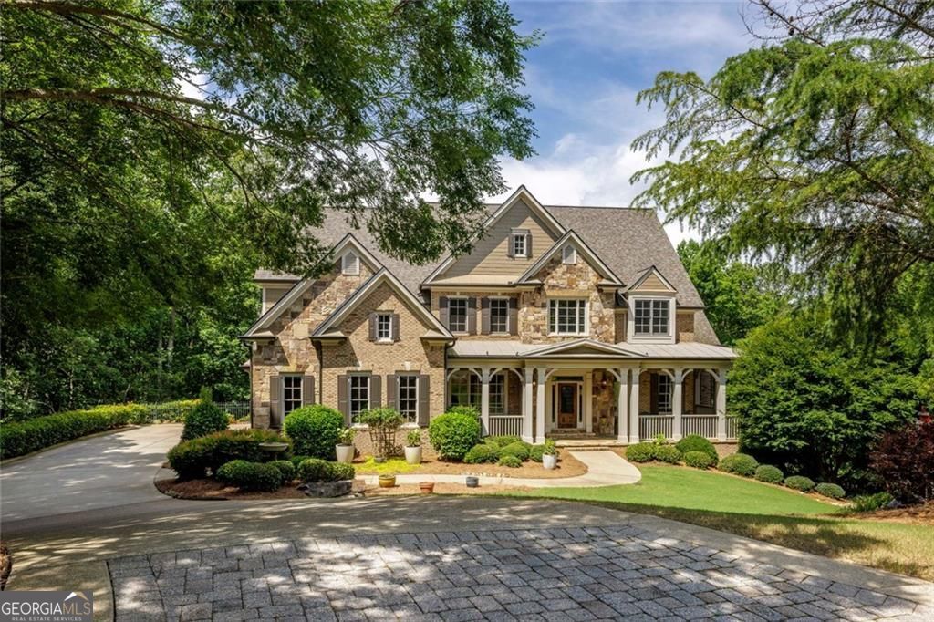 Absolutely stunning and impeccably maintained, this exquisite residence is nestled on a beautifully landscaped 1.56-acre private cul-de-sac lot in the highly sought-after swim and tennis community of Litchfield Hundred. Set amidst peaceful wooded surroundings, this exceptional home offers a perfect blend of timeless elegance, gracious living, and modern comfort-all in a premier Roswell location. A charming front porch and a grand two-story entry foyer set the tone for the sophisticated interiors, where gleaming hardwood floors, soaring 10'+ ceilings, arched doorways, and detailed moldings define each spacious room. The impressive layout includes a banquet-sized dining room with tray ceiling and Butler's Pantry, a formal living room or study with fireplace and coffered ceiling, and a dramatic fireside family room with custom built-ins, coffered ceiling, and French doors that open to a serene screened porch with its own stone fireplace-perfect for year-round entertaining.At the heart of the home, the beautifully appointed kitchen is a true showstopper-featuring painted cabinetry, granite countertops with tile backsplash, a large center island with breakfast bar, stainless steel appliances including a double oven and gas cooktop, and a sunlit breakfast room. The kitchen seamlessly flows into the family room with its tongue-and-groove vaulted and beamed ceiling and striking floor-to-ceiling stone fireplace. The luxurious main-level owner's suite offers a peaceful retreat with a deep tray ceiling, sitting area, dual walk-in closets, and a spa-inspired bath complete with double vanities, a jetted tub, and a glass-enclosed shower. Upstairs, four spacious ensuite bedrooms offer comfort and privacy for family and guests, each with generous closets and beautifully appointed baths. A large bonus room provides a flexible space perfect for a media room, playroom, or teen hangout, while a dedicated office/study area is ideal for working or learning from home. The upper level is thoughtfully designed to meet the needs of modern living, with room to grow and gather. The daylight terrace level expands the home's living and entertaining options even further, featuring warm and inviting finishes throughout. A fireside living room opens to a full kitchenette and dining area, creating a self-contained living space perfect for long-term guests or multigenerational living. A private bedroom and full bath, along with an expansive additional living area-ideal for a home gym, game room, or studio-offer endless flexibility. French doors provide walk-out access to the backyard terrace and firepit area, surrounded by wooded serenity and lush landscaping. The expansive, private backyard offers ample space for a pool, making it ideal for future outdoor enhancements. With its own private entrance from the driveway and garage, this level functions beautifully as an in-law or guest suite. Additional highlights include a three-car garage, rear staircase, and abundant natural light throughout. Enjoy the incredible neighborhood amenities including clubhouse, swimming pool, tennis courts, pickleball, a scenic lake with fishing dock, playground, gazebo, and easy access to Leita Thompson Park with their beautiful walking trails and Mountain Park Wildlife Sanctuary. This is a rare opportunity to own a truly remarkable home in one of Roswell's most desirable communities-move-in ready, richly detailed, and absolutely unforgettable.