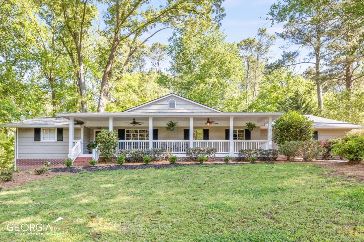 When you step into this Whitlock Heights home you will be astounded by its mix of retro-cozy and updated spaces. There is SO MUCH SPACE in this house! Wide open rooms, loaded with light and perfect for both casual living and elegant entertaining. There are wonderful surprises at every turn: covered front porch overlooking brand new landscaping in the front yard, welcoming front room for living and dining with fireplace and built-ins, a perfect guest suite to the left side offering loads of privacy. The kitchen boasts sunny breakfast room, separate ovens, second island sink, and unique hearth fireplace (since everyone gathers in the kitchen anyway!). It opens to a massive great room with beamed & vaulted ceilings leading to a covered screened porch running the entire width of the house. Primary bedroom overlooks the private back yard while 2 additional bedrooms access a jack-n-jill bath. 5th bedroom with adjacent full bath off the kitchen is also the perfect office, playroom or TV room. Cute wet bar and fully renovated laundry room. Hardwood floors, newer carpet and fresh paint make this home move-in ready. The house was built in 1955, but check out these details: new roof and gutters (2022), tankless water heater, upgraded plumbing and ductwork, extensive new landscaping (2023), fire pit (2021), interior paint (2023) and more. A 30 minute walk (or 5 minute bike ride) to the Marietta Square, convenient to numerous area parks as well as City Club Marietta and it's 18 hole golf course, this home is everything you've been searching for!
