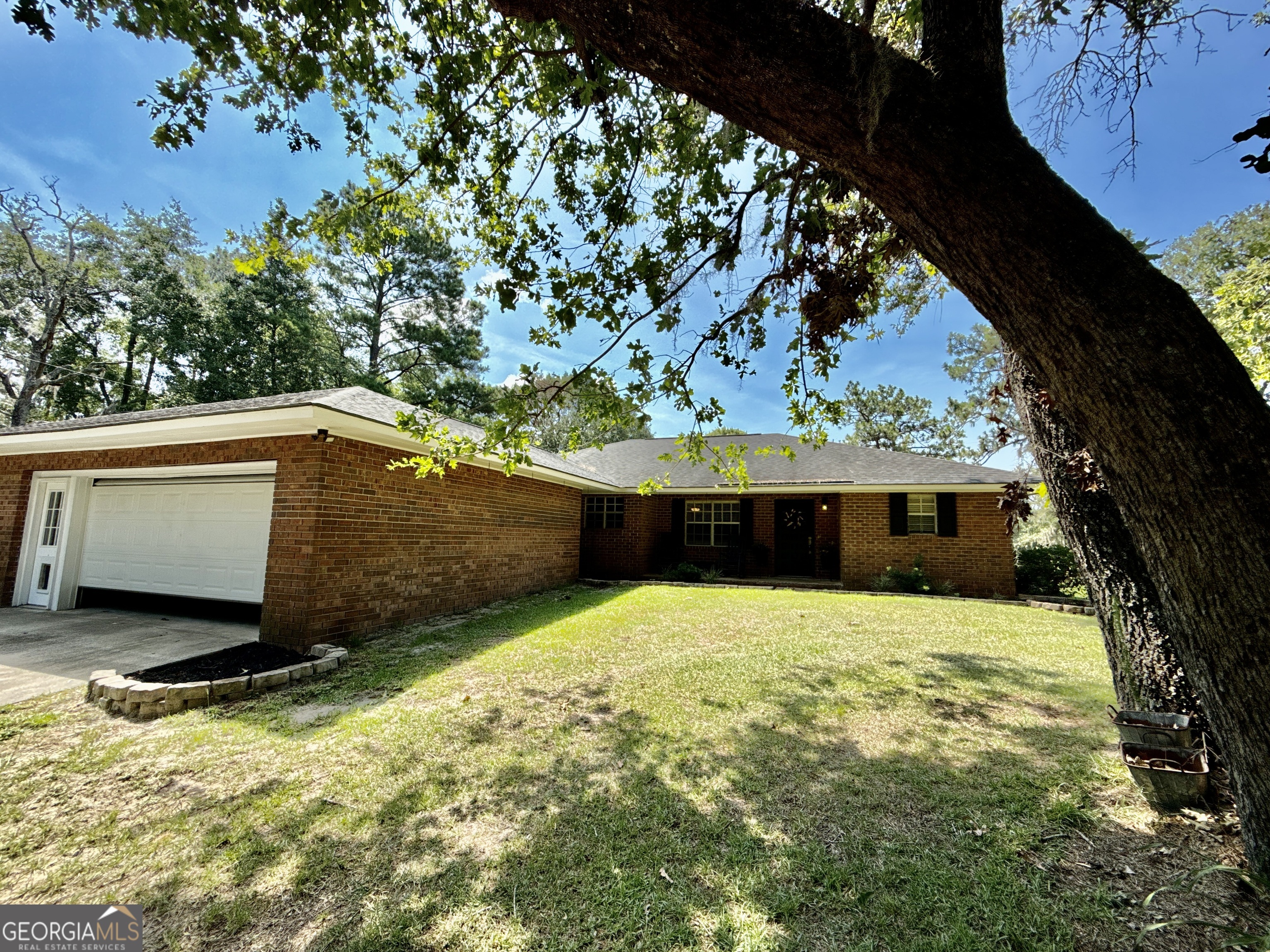 Welcome to 3978 WC Hodges Rd - a true outdoor paradise nestled in the desirable Middle Ground community of Bulloch County. This 1,896 sq ft ranch-style home sits on 47.7 acres of rolling woods and fenced pastures, offering endless possibilities for country living. The 3 bed, 2 bath home features an open floor plan, split bedroom layout, breakfast bar, dining area, and a cozy wood-burning stove. Enjoy the outdoors from the expansive covered back patio with access from both the living room and master suite, plus an outdoor shower and bathroom for added convenience and the ideal place to entertain or spend your mornings and evenings. The property is fully equipped for livestock with fenced and cross-fenced pastures, a large banked-roof barn with hay loft, two pole barns, and two grain bins. Additional features include a spacious workshop with a 10,000 lb above-ground automotive lift, multiple dog kennels, and an underground pet fence system spanning across approx. 1 acre. Explore the trail system winding through oak hammocks and hardwood bottoms-complete with deer stands, food plots, and a prime dove field. A detached game room building adds even more versatility to this exceptional property, with endless possibilities to be converted to best suit your vision. Abundant wildlife including deer and turkey, allowing you to enjoy your own private hunting preserve. A rare opportunity for serene living with unlimited potential.