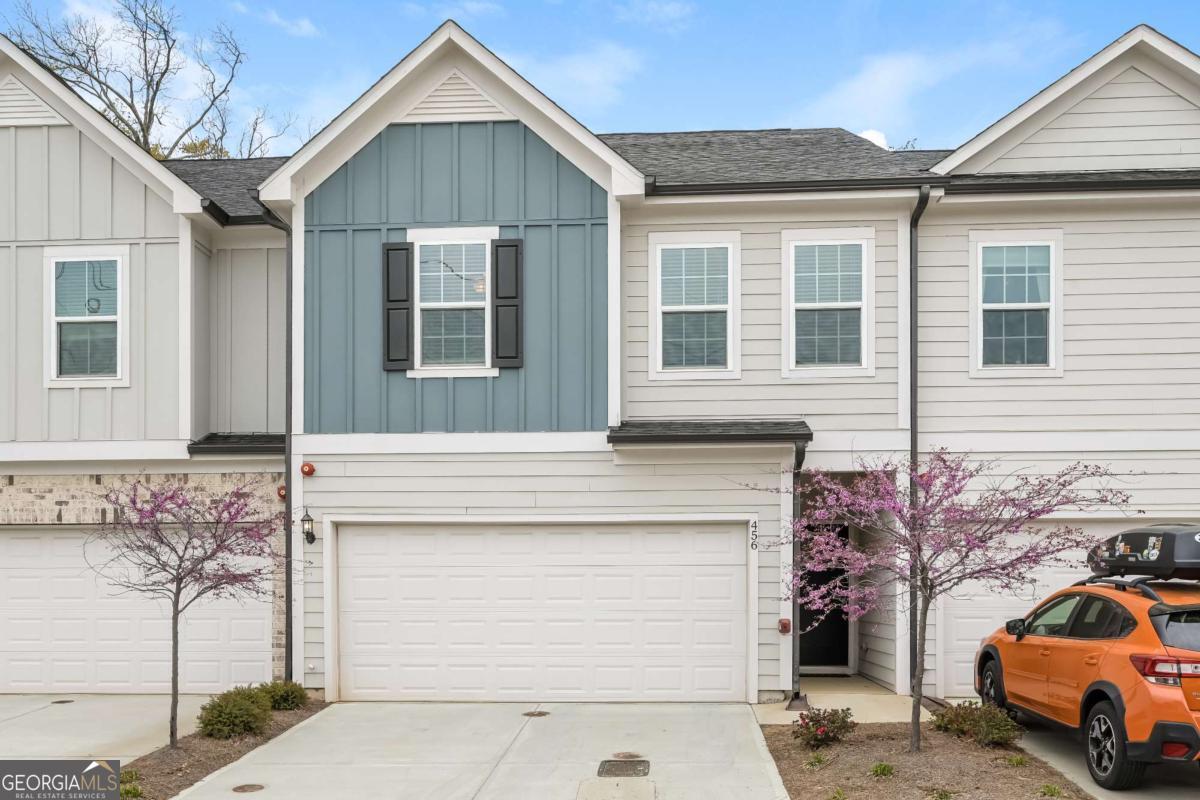 This meticulously maintained, like-new townhome offers carefree living within walking distance to the Marietta Square with 2100 sqft. The open main level features engineered wood floors, a chef's kitchen with white quartz counters, a five-burner gas cooktop, an expansive island, and stainless steel smart appliances, seamlessly flowing into the open dining area and sunlit living area with its wall of windows-perfect for entertaining. Step outside to the back patio on one of the more private lots in the neighborhood. Upstairs, walk right into the loft which provides great space for a second living area, perfect for movie nights or a home office. Two sun-filled bedrooms share a hall bath, while a spacious laundry room adds convenience upstairs. The private primary suite is its own sanctuary with double-door entry and ample lighting. The spa-like primary bath is covered in gorgeous tile with a frameless glass fully tiled shower, separate soaking tub, dual vanity, linen closet, and a large walk-in closet. Additional conveniences include a two-car garage with electric car charging and numerous smart home features. An HOA that handles exterior maintenance, lawn care, and termite control makes for carefree living. Community perks include a dog park, guest parking, fire pit, and walking trails. Don't miss your chance to enjoy a walkable lifestyle in this highly desired location, just a short walk over the pedestrian path to Marietta Square- with its weekly farmers market, food hall, frequent events, with local dining and shopping options!