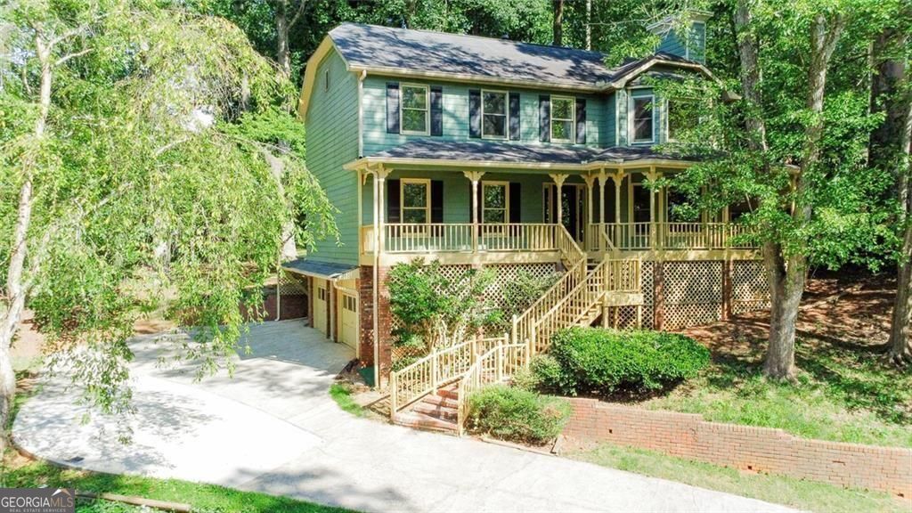 Tucked away in a desirable East Cobb neighborhood in the Lassiter HS district, this spacious 4-bedroom, 3.5-bath home offers comfort, character, and convenience-with walkable access to nearby amenities. Perfect for customization, this home is full of potential and thoughtful details throughout. A charming front porch with a swing welcomes you home, offering a perfect spot to unwind and enjoy the quiet surroundings. Upstairs, all four generously sized bedrooms feature hardwood floors and ample closet space. The primary suite includes two closets-one with a convenient laundry chute leading directly to the laundry room below-and a private bath with a soaking tub, separate shower, and plenty of natural light. The main level boasts a bright eat-in kitchen and a formal dining room, ideal for entertaining. NEW carpet has been installed in the living room, front room, basement and both staircases, adding fresh comfort throughout the common areas. Just off the dining room, you'll find a versatile four-season sunroom that overlooks the backyard, creating a perfect spot for morning coffee or evening relaxation. Step outside to the spacious back deck-an ideal space for a hot tub, outdoor dining, or lounging. Enjoy the tranquil sounds of a small water fountain and pond tucked just off to the side, adding to the peaceful atmosphere. The partial basement includes a full bathroom with flexible bonus space ready to suit your lifestyle-whether it's a guest suite, home gym, office, or media room. Don't miss this rare opportunity to make a great home your own in one of East Cobb's most desirable communities!