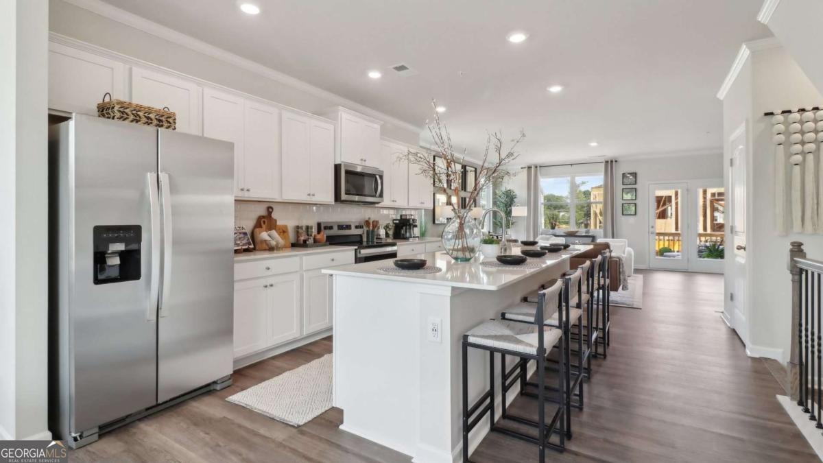 New beautifully crafted easy living three story "Asbury 1" floor plan in the award winning Hapeville community 10 minutes from Hartfield Jackson ATL Airport. The Asbury 1 floorplan offers three bedrooms each featuring en-suit bathrooms, a half bath on the second level totaling 3.5 baths in total. The ground level includes a two car garage, a nice sized bedroom with an en-suit bath. The second level includes an open concept layout with kitchen overlooking dining and family room. Revwood flooring throughout the main, chef-inspired kitchen offers a large island with quartz countertops and stainless-steel appliances. The upstairs features two generously sized bedrooms along with a washer & dryer area, luxury vinyl stairs throughout along with high ceilings. In addition to the fantastic location, home owners will enjoy the close proximity to a selection of bars and restaurants in the Hapeville location with a short 15 minute commute to midtown Atlanta.