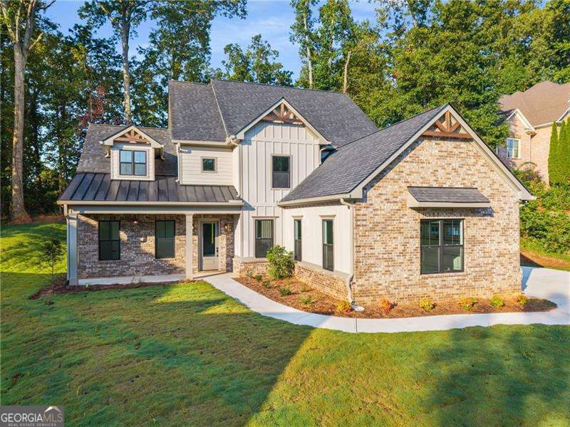 Located in the prestigious Traditions of Braselton, this brand-new construction home offers the perfect blend of luxury, convenience, and modern elegance. Move-in ready, it welcomes you with a charming rocking-chair front porch, an expansive three-car garage, and curb appeal that sets the tone for what's inside. Step into the soaring foyer, where a versatile flex space awaits-ideal for a home office, playroom, or formal sitting area. The open-concept layout is designed for both comfort and entertaining, featuring top-tier finishes throughout. At the heart of the home, the gourmet kitchen impresses with shaker-style cabinetry, quartz countertops, stainless steel appliances, a wine fridge, a coffee bar, and a spacious walk-in pantry. The kitchen flows seamlessly into a two-story family room with a cozy fireplace and continues to a covered back porch with its own outdoor fireplace, overlooking a level backyard perfect for gatherings, recreation, or quiet retreats. This thoughtfully designed home offers a rare double owner's suite layout, perfect for multi-generational living. The main-level suite features a spa-like bath with a soaking tub, frameless glass shower, dual vanities, and a large walk-in closet. Upstairs, you'll find the second owner's suite, two additional bedrooms, a family room, and a media room, providing plenty of space for everyone. Beyond the home itself, residents of Traditions of Braselton enjoy access to premium resort-style amenities including a fitness center, junior Olympic pool, tennis and pickleball courts, and an on-site restaurant. Conveniently located just minutes from Publix, shopping, and dining, this is an incredible opportunity to own a stunning, move-in ready home in one of Georgia's most sought-after communities.