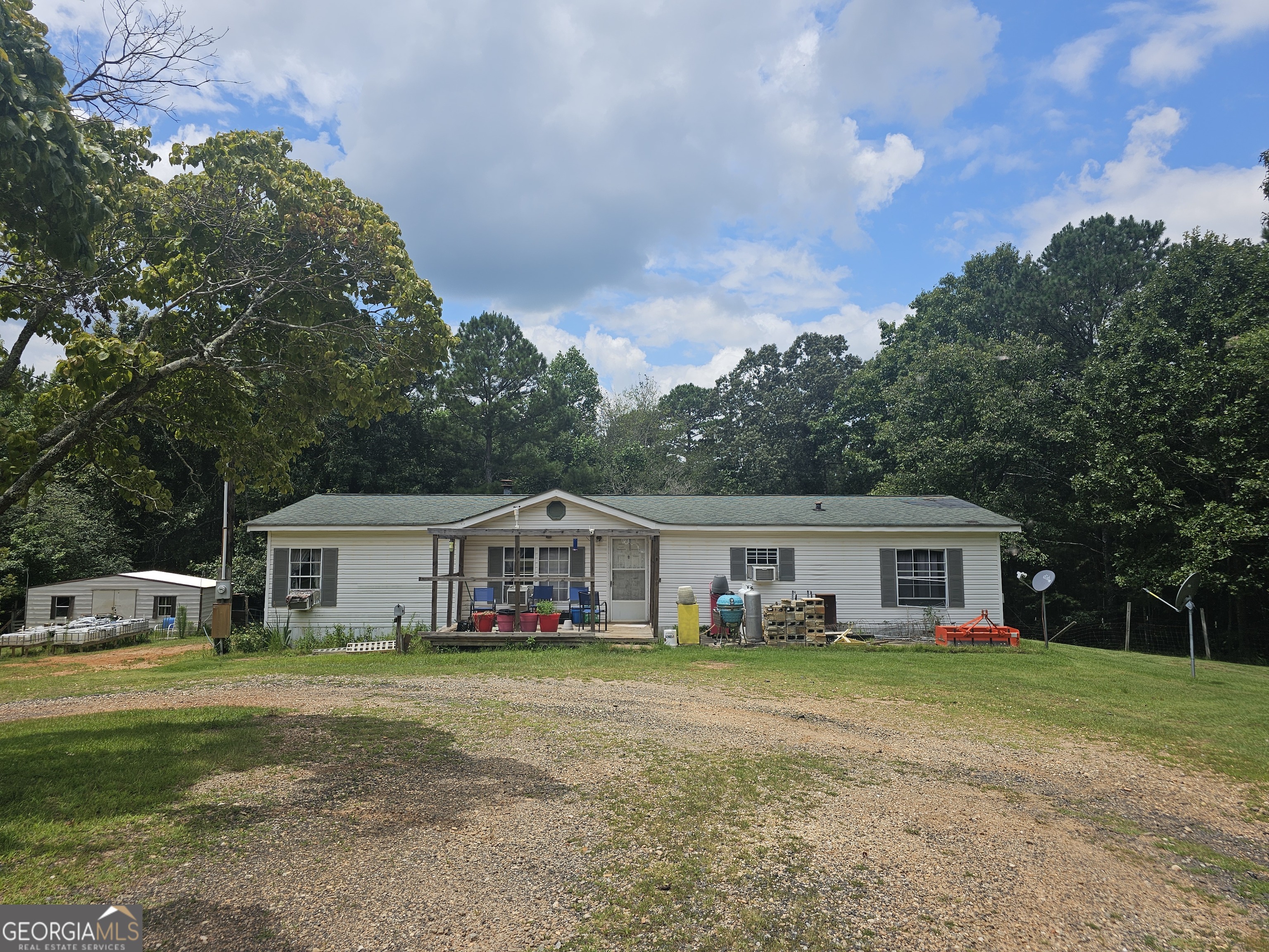 Welcome to 267 Williams Rd in Tallapoosa, GA - a private 11.71-acre retreat featuring a 3-bedroom, 2-bath manufactured home with over 1,400 sq ft of comfortable living space. This well-maintained home offers a split-bedroom floor plan with a master suite on the main level, a spacious living area with a wood-burning fireplace, and a cozy layout perfect for peaceful country living. The property boasts a mix of wooded and open land, ideal for homesteading, recreation, or simply escaping the hustle and bustle. Additional highlights include propane and wood heating options, ceiling fans, window units for cooling, and a large 30x40 pole barn. No HOA, low annual taxes, and located at the end of a quiet road for maximum seclusion. A spring-fed creek adds even more charm to this serene rural property. Schedule your private showing today!