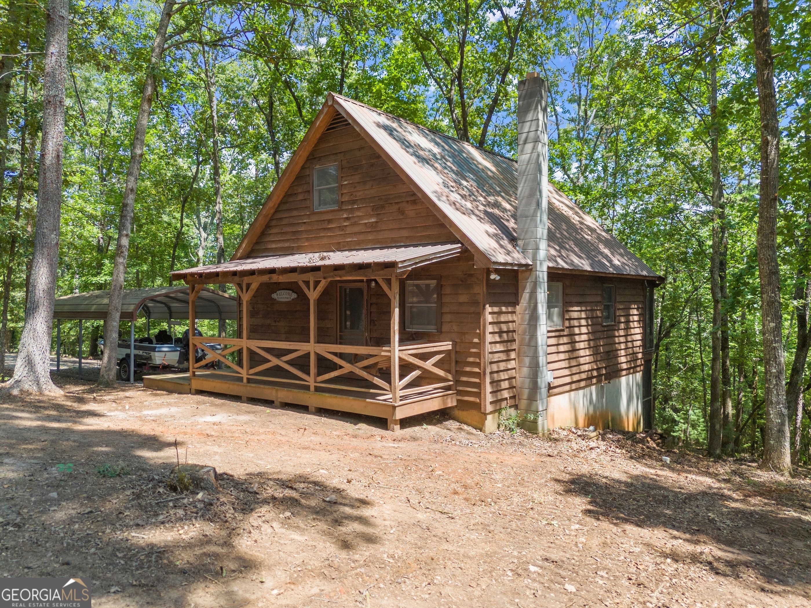 Nestled on more than four acres, this mountain retreat strikes the perfect balance between peaceful seclusion and easy access to town-just minutes from the University of North Georgia and downtown Dahlonega. The cabin's light-filled interior showcases vaulted ceilings and hardwood floors on the main level, creating a warm and inviting atmosphere. The primary suite is conveniently located on the main floor, with two additional bedrooms on the lower level to comfortably accommodate family and guests. A versatile bonus room upstairs offers even more living options. Outdoor living shines with two screened porches designed for year-round enjoyment. The main-level porch features a wood-burning fireplace and cozy swing, while the lower-level porch includes a hot tub-ideal for soaking under the stars on cool evenings. Surrounded by seasonal mountain views, this property provides a rare sense of privacy yet remains close to Lumpkin County's best amenities, including six wineries within five miles. With a detached carport, expansive gravel drive, and plenty of parking, hosting guests is a breeze. Whether you're searching for a full-time residence, a weekend getaway, or an investment opportunity, this unique cabin delivers mountain living at its finest.