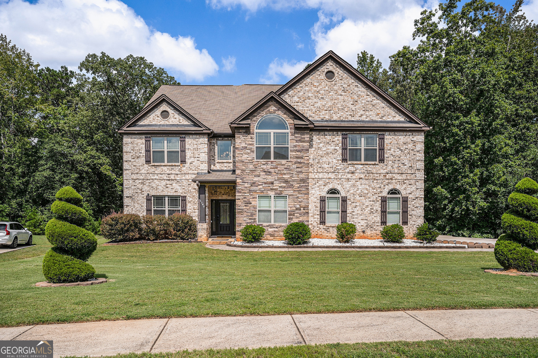 Nestled in the prestigious Bellah Landing neighborhood of Stockbridge, GA, this stunning three-story, four-sided brick traditional residence presents refined craftsmanship and functional design, featuring six spacious bedrooms and five baths thoughtfully arranged for both comfort and versatility; step inside to be greeted by a two-story foyer, coffered ceilings, arched passageways, iron spindle railings, and rich hardwood floors that flow throughout, complemented by upscale touches such as tray ceilings, a cozy family room fireplace, and a gourmet kitchen adorned with granite and Travertine surfaces plus a convenient keeping room. With a two-car side-entry garage, upper-level laundry, multiple walk-in closets, a luxurious owner's enclave with a sitting area, and a pull-down attic for added storage, this home stands out as a masterclass in design. Outside, a generous level lot provides room for outdoor living in a serene setting, while the neighborhood's quiet charm is enhanced by proximity to Woodland schools, local parks, shopping centers, and easy access to I-75. Whether hosting or relaxing, this home seamlessly blends elegance, practicality, and location.
