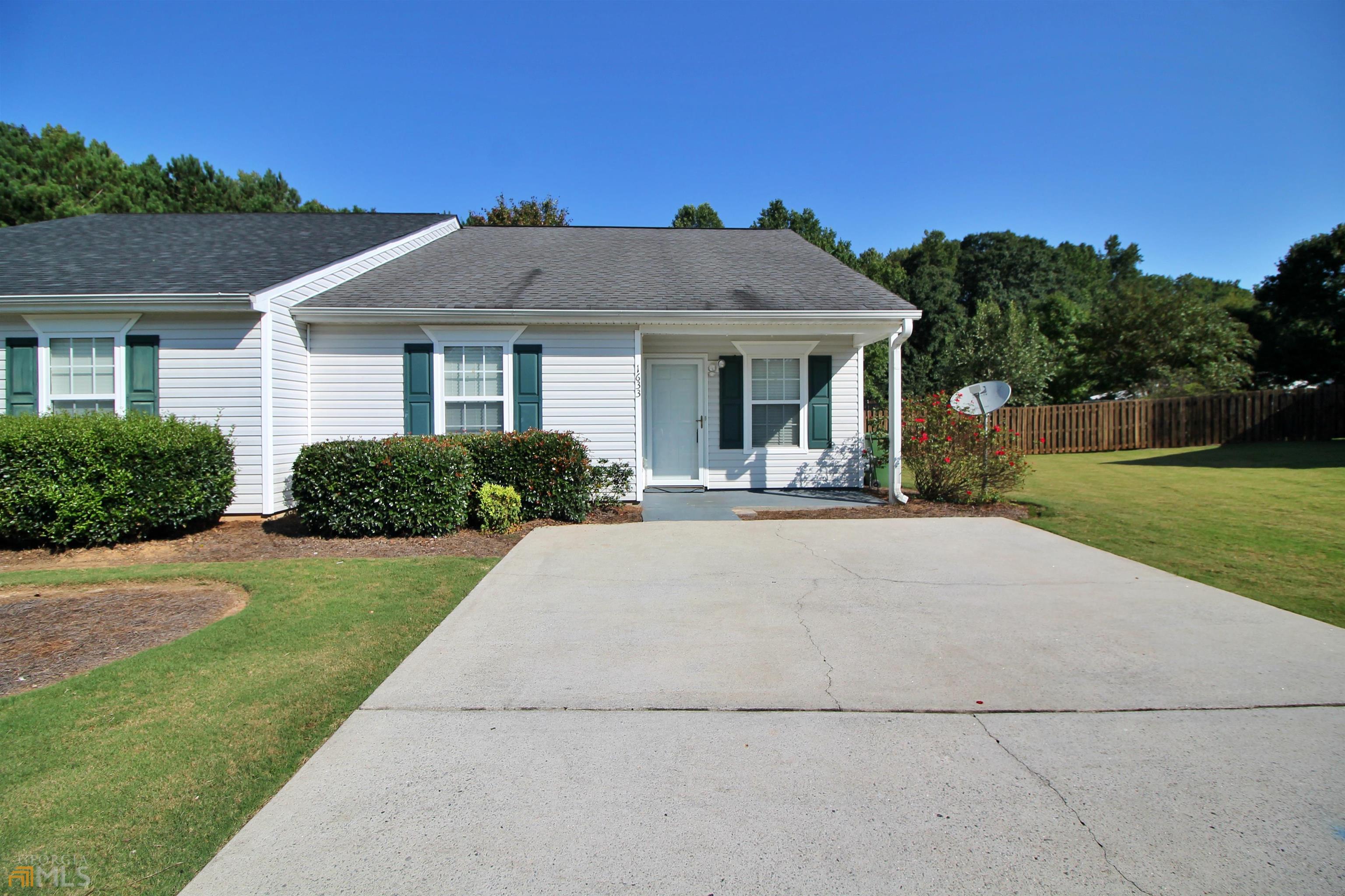 Welcome home to this beautifully maintained 2 bedroom, 2 bathroom townhome in the heart of Griffin!! This home offers a galley kitchen which opens into a dining area and spacious living room complete with a fireplace! Large walk in closets in both bedrooms. Master bath has been renovated to include tile walk in shower and double vanity! Laundry room has ample space and the impressive pull down attic offers even more storage! Large privacy fenced back yard with wood patio and storage building with shelving. Water heater is approximately 2 years old. You do not want to miss this opportunity! Schedule your showing today! Front yard maintenance is included with HOA fee.