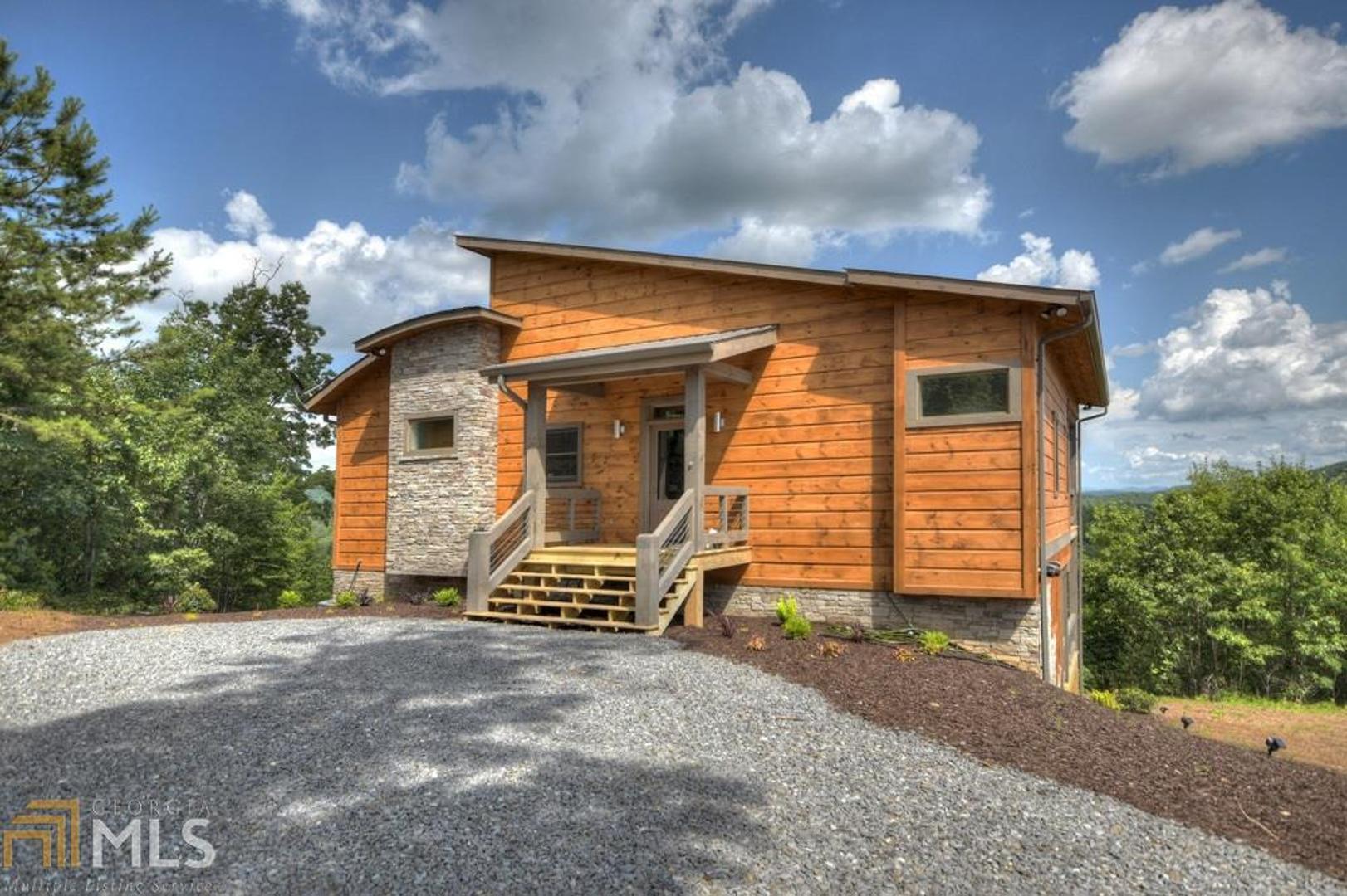Sizzlin’ sleek style with a little southern flare… this chic 3BR/3BA masterpiece brings mountain style to a whole new level. This stunner showcases what mountain living is all about whether you’re inside with an abundance of glass ushering the views indoors or “living the life” outdoors from your own private party porch complete with a fireplace. The design of this home is a rare find in North Georgia. Not only does it offer a unique exterior, but it also offers modern rustic finishes galore – tile bathrooms, custom cabinetry, specialized lighting and plumbing fixtures, hardwoods and tile throughout the main, full finished basement, and more. Located in the highly sought after Cooswattee subdivision, this community offers all paved access, gated entrance, clubhouse, community pool, and tennis courts. Savor the mountain lifestyle in style! *First 4 photos are representative & last 4 are actual*
