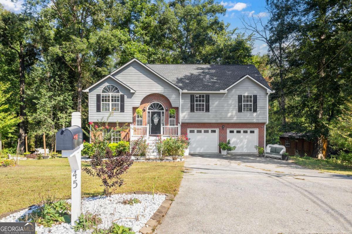 This is the one you've been waiting for! Meticulously maintained, this home boasts nearly 2200 sf of gorgeous space for you and your loved ones! Bathed in natural light and perched above a trickling backyard creek, this home feels more like a permanent retreat! With an entire suite downstairs with it's own bathroom and private deck, this layout is perfect for multigenerational living! The over-sized lot is home to a sweet little greenhouse and is bursting with colorful flowers and plants that enhance the beauty of the property. Sip cider and roast marshmallows at your own dedicated, charming fire pit area this fall! Store all your toys and tools in the large outbuilding, or make a separate private workshop or she-shed, and still have room in the double car garage! Its fenced-in back yard means all the littles are contained and ready to move in! Septic tank was just pumped and inspected in July, so you have peace of mind going in! This property offers everything! If all that wasn't enough, the community hosts a fully stocked lake within walking distance from the house. Take a lawn chair and relax watching the birds fly overhead or bring your fishing pole and make a day of it! A community that offers so much, and yet NO HOA! Does it get any better than this? With this home's perfect size and location coupled with it's function and charm, at this fantastic price, it won't last long! Scoop it up now so you don't miss it!