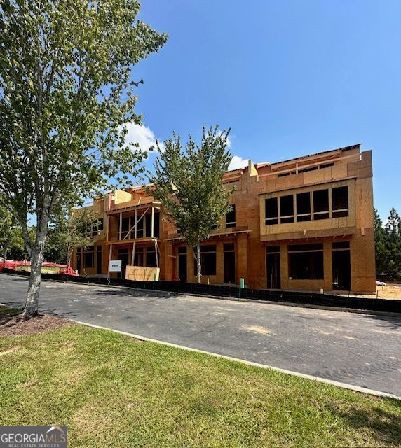 New Construction Townhome in the Heart of Downtown Senoia!**Photos are a representation of finishes in another community and not actual build** Under construction. Welcome to this beautifully crafted three-story townhome by JW Collection, ideally situated within walking distance to Senoia's charming shops, restaurants, and entertainment. Enjoy the convenience of small-town living just 40 minutes from Hartsfield-Jackson Atlanta International Airport. This thoughtfully designed home offers over 3,200 square feet of stylish living space. The street-level entry features a two-car garage with additional golf cart parking available, a spacious bedroom with a full bath, and a flexible space perfect for a home office or fitness room. The main (second) floor is made for entertaining with an open-concept layout featuring a great room with fireplace, dining area, and a keeping room-all opening to a covered 10'x12' deck. The gourmet kitchen boasts stainless steel KitchenAid appliances, a gas cooktop with custom wooden vent hood, quartz countertops, and a walk-in pantry with beautiful wooden shelving. A powder room completes this level. On the top floor, you'll find a luxurious owner's suite with a large tiled shower, dual vanities with quartz countertops, and a spacious walk-in closet outfitted with a custom closet system. Also upstairs is a secondary bedroom with full bath and a versatile media room. Step outside to your private 24'x10' rooftop sky terrace with stunning views of Senoia and Gin Property neighborhood. With a timeless exterior of brick and Hardie plank, this townhome blends quality craftsmanship with modern living in one of Georgia's most beloved towns. Don't miss this opportunity to make downtown Senoia and the Seneca at Gin Property your home.