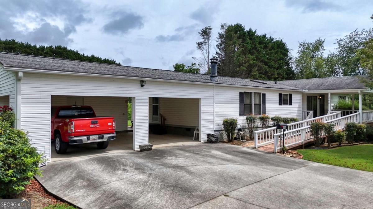 Spacious & affordable home just minutes from downtown Hiawassee! Welcome to 266 Garden Lane - this well-maintained 3-bedroom, 2-bath home offers comfort, space, and convenience in a prime location so close to Lake Chatuge! Situated just minutes from downtown Hiawassee, this property provides easy access to shopping, dining, medical facilities, and the best of North Georgia's and North Carolina's outdoor recreation spots. Step inside to find generous living areas designed for both relaxation and functionality. The open-concept living and dining area offers ample room for entertaining and everyday living, while the spacious kitchen features abundant cabinetry, plenty of counter space, and a convenient layout perfect for any home chef. A separate laundry room and a bonus family room off the kitchen add even more versatility to the floor plan. Enjoy the outdoors year-round with a covered front porch and a huge screened-in back porch - ideal for morning coffee, evening meals, or entertaining guests. A large two-car carport includes an attached storage area/workshop and a ramp for easy access to the front door, enhancing both convenience and accessibility. Recent updates include a new HVAC system and hot water heater (2025), as well as a new roof (2022), giving peace of mind for years to come. Don't miss your opportunity to own this spacious, updated, and affordable home!