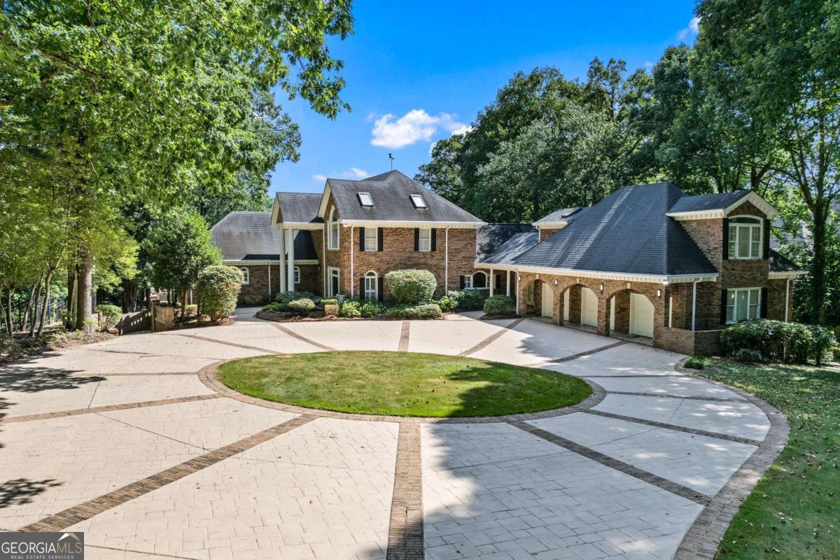Experience lakeside luxury at its finest in this fully renovated, all-brick estate on prestigious Lake Spivey-truly a rare jewel and probably the best home in the entire area, virtually impossible to find anything like it. Secured behind electronic gates, this magnificent mansion spares no expense: HGTV-inspired designer finishes throughout, soaring two-story living spaces, and an expansive terrace level featuring its own kitchen. Home features a separate studio apartment. Two sumptuous master suites, plus three additional bedrooms, three full kitchens, two laundry rooms, and four-car garage parking offer unparalleled flexibility. Entertain or unwind on broad stone-balustrade porches overlooking your private two-slip, two-story dock with gazebo...option to add custom pool. A grand two-story living room framed by an upstairs mezzanine and huge loft gallery exemplifies superior quality and impeccable condition. This turnkey masterpiece delivers every luxury imaginable in serene lakefront living-an unparalleled opportunity in the Lake Spivey market.