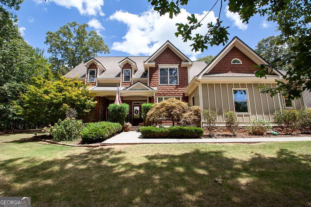 Beautiful craftsman home in the stately Branson Mill neighborhood nestled in highly sought-after north Cartersville! This executive home sits on a private 3-acre lot with a partially wooded backdrop. Watch the deer and listen to the wind in the trees while you swing on your spacious front porch or relax on your large, partially covered back deck with a stunning tongue and groove ceiling and Trex decking! The home has stone and shaker accents with board and batton in front! Hardiplank siding wraps the rest of the home to ensure long-term peace of mind. The great room features soaring ceilings, custom built-ins, a stone fireplace, and wall-to-wall windows to let in the sights of nature with all the natural light. The spacious kitchen boasts plenty of rich wood cabinets, granite countertops, and stainless-steel appliances. Take your pick of the two breakfast areas off the kitchen with one boasting a gorgeous, vaulted tongue and groove ceiling! Separate dining room with custom molding. The oversized master suite has tray ceilings, his and her closets, and a private door to the back deck. The large master bathroom contains a double vanity, soaking tub, separate shower, and large picture window. The home has rich hard wood floors in the living areas, with craftsman details sprinkled throughout. The upstairs offers three large bedrooms. One bedroom has its own private bathroom while the other two are joined by a full jack and jill bath. In addition to the attached two-car garage, the home also has a detached two-car garage with HVAC, custom work space, and a living quarters upstairs- ideal for an in-law/teen suite or office, already stubbed to easily add a bathroom in the future. The property neighbors the large, community saltwater pool and playground. Simply walk next door for swimming and recreation while still being totally secluded from the outside in your own private oasis. The roof is about 12 years old and the water heater is only three years old. Very low annual HOA and NO initiation fee!