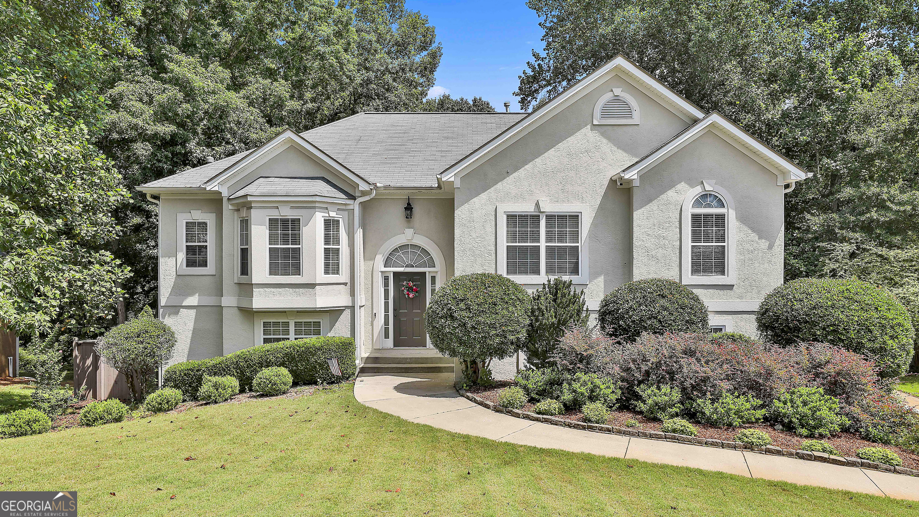 SPECTACULAR, UPGRADED & VERY WELL MAINTAINED HOME OFFERING LOTS OF SPACE & GORGEOUS, PRIVATE BACKYARD! Lots of NEW both inside & outside w/ updated SS Smart Appliances inc Frig & slimline microwave, NEW Hardwoods in Hall, Bedrms & stairs (Hardwds nearly everywhere!). Enjoy the open Kitchen w/ granite counters & level b'fast bar for quick meals. Fresh bright white cabinets & subway tile backsplash for more updates. Vaulted Family rm w/ cozy fireplace & gas logs is perfect for cool evenings. You'll love the all NEW lighting & Fans nearly throughout for that on-trend look. Fresh neutral paint on walls lets you set the tone of your choice. The Primary suite w/ sitting area also has a cool look updated Bathrm w/ framed mirrors, quartz counters, garden tub & sep Shower. Downstairs offers big Family rm, office, lg Bedrm/Multipurpose rm w/ closet & full bathrm. Add'l unfinished area perfect for storage. Enjoy the outdoors on the Luxury 'Trex' Deck w/ stairs to patio below + waterproof ceiling under deck lets you enjoy patio in all weather. The Deck & Patio overlook the large lush zoysia lawn that has been professionally redone w/ convenient side path on the side. Private Backyard w/ greenspace & trees beyond the fence. The home's exterior & Newer fence have been professionally painted. Let the NEW Irrigation system w/ cost saving sep water meter, manage the lawn for you. Long driveway & side entry garage w/ Lg Parking Pad! Lots more with NEWer Roof, NEWer Hot Water Heater & NEWer HVAC w/ mtc plan. THIS IS A QUALITY MOVE IN READY HOME - Imagine the Possibilities! Enjoy Woodstream & it's terrific amenities to include Pool, Tennis, Clubhouse & Lake plust quick access to Shops/Restaurants, I-85 to Atlant & Airport!.