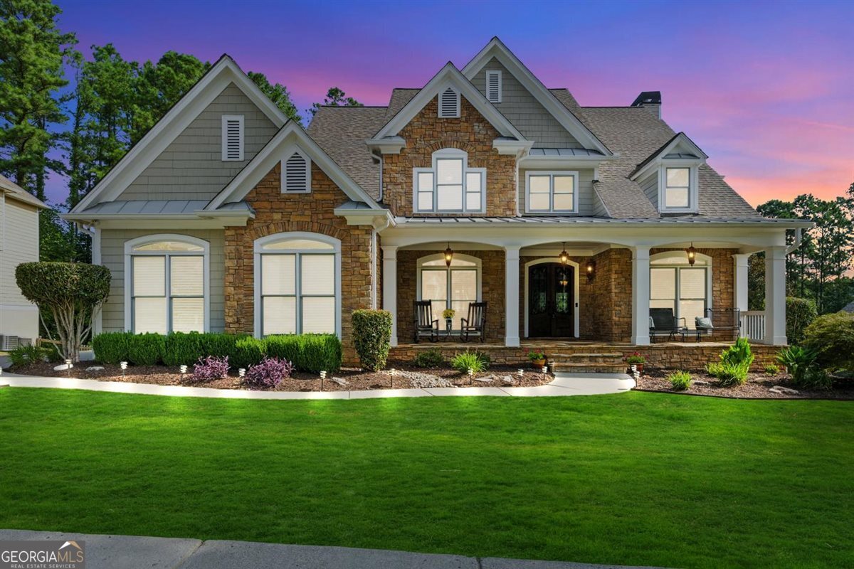 This beautifully maintained residence offers the perfect blend of elegance, comfort, and functionality-truly a place you'll be proud to call home. The gorgeous stacked stone front is the perfect backdrop for this amazing rocking-chair front Porch. Step through the wrought-iron double front doors and 2-story Foyer into a thoughtfully designed main level ideal for both everyday living and entertaining. The sunken family room, centered around a cozy gas-log fireplace with custom built-ins, flows seamlessly into the Breakfast Area and open Kitchen. A wall of windows allows natural light to fill the space, while offering peaceful wooded views. Step out to the oversized Trex deck-perfect for gatherings or quiet mornings with coffee. Flexible living spaces abound, including a formal Living Room and private Home Office. A butler's pantry connects the Kitchen to a spacious Dining Room-ideal for holidays, celebrations, or casual weeknight dinners. Hardwood floors run throughout the main level, with newly installed carpet upstairs. Retreat to the expansive Primary Suite, large enough to accommodate a full furniture suite, with a spa-like bathroom featuring double vanities, a soaking tub, tiled shower, and oversized walk-in closet. Three additional large bedrooms upstairs provide comfort and space for family and guests alike. The full, unfinished daylight basement offers endless possibilities-already stubbed for a bath, with a new double exterior door and walkout access to a private patio and terraced backyard. Designed for both beauty and function, the yard includes flat green space, garden areas, and even a firepit tucked into the woods. Additional highlights include a 3-car garage with brand-new doors, level driveway, and professionally landscaped curb appeal that welcomes you home. Nestled in the sought-after golf cart-friendly Seven Hills community, enjoy world-class amenities: an Olympic-size pool with water slides, playgrounds, tennis and pickleball courts, nature trails, dog park, pavilion, and amphitheater for neighborhood events. The lifestyle here feels like a permanent vacation! Conveniently located near highways, shopping, dining, schools, Lake Allatoona, Red Top Mountain State Park, Kennesaw Mountain National Park, golf courses, and more. This stunning home offers a resort-style lifestyle to enjoy every day. Don't miss your chance to make it yours!