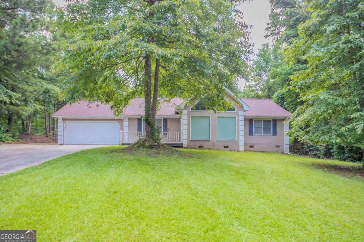Single-story ranch in Countyline Acres offering flexible space and peaceful surroundings. This three-bedroom layout features a vaulted living room with a fireplace, an open-concept kitchen with solid surface counters and eat-in area, and a spacious laundry off the main level. The large lot offers privacy, wooded edges, and a rear deck for outdoor living. Bonus garage parking includes both an attached and detached garage-great for additional storage or workspace. No HOA or rental restrictions, just minutes from downtown Palmetto and easy access to I-85.