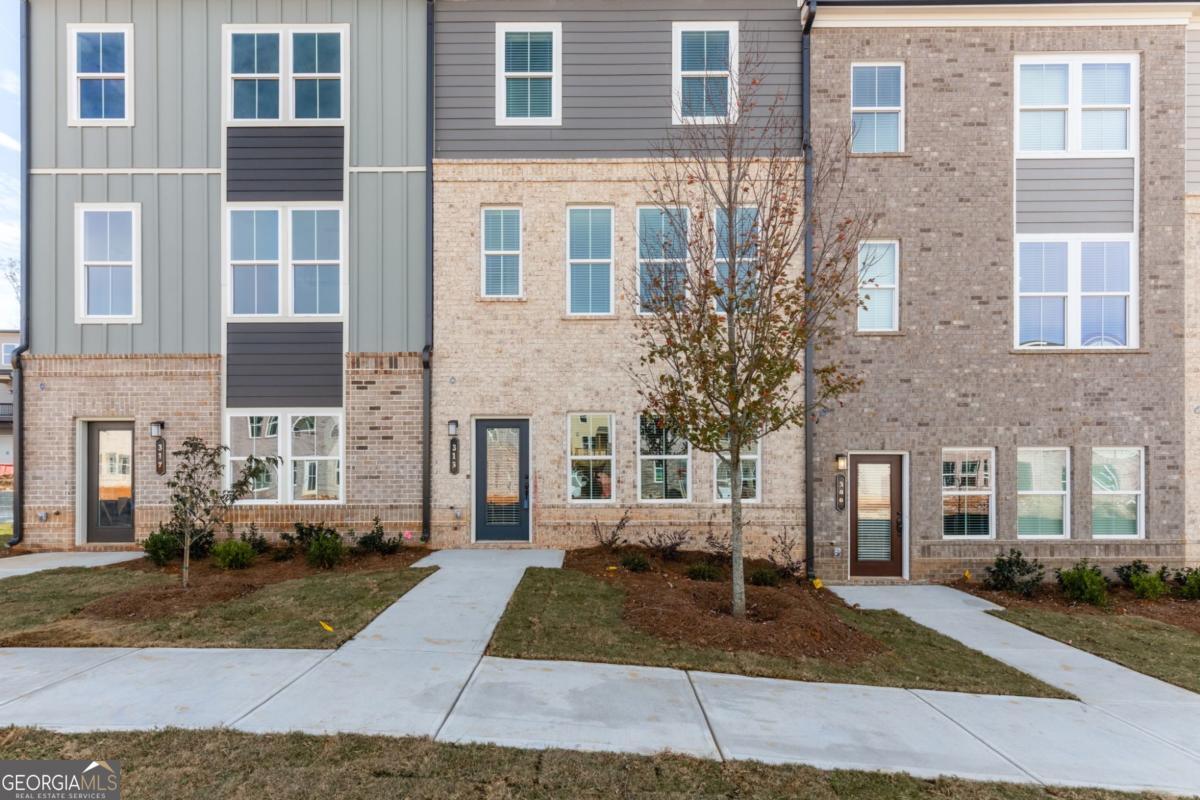Like-New Luxury in a Prime Acworth Location! Discover this stunning 3-story townhome in a highly sought-after community with top-rated schools. Built with style and comfort in mind, it features a huge kitchen island with quartz countertops, upgraded lighting, SS appliances, and soaring 9-foot ceilings on every level. Enjoy the outdoors with an extended covered deck overlooking private views - perfect for grilling, relaxing, or entertaining friends. The versatile lower level can be transformed into a 4th bedroom, home office, gym, playroom, or creative space to suit your needs. Upstairs, the oversized primary suite offers double vanities, a spacious walk-in closet, and the convenience of an upper-level laundry room. The open-concept main floor is bathed in natural light, creating a warm, inviting space you'll love coming home to. This vibrant community will soon offer incredible new amenities - including a lake, clubhouse, swimming pool, pickleball and tennis courts, parks, playgrounds, and scenic walking trails - making it not just a home, but a lifestyle. Schedule your private tour today and see why this home is a standout in Acworth!