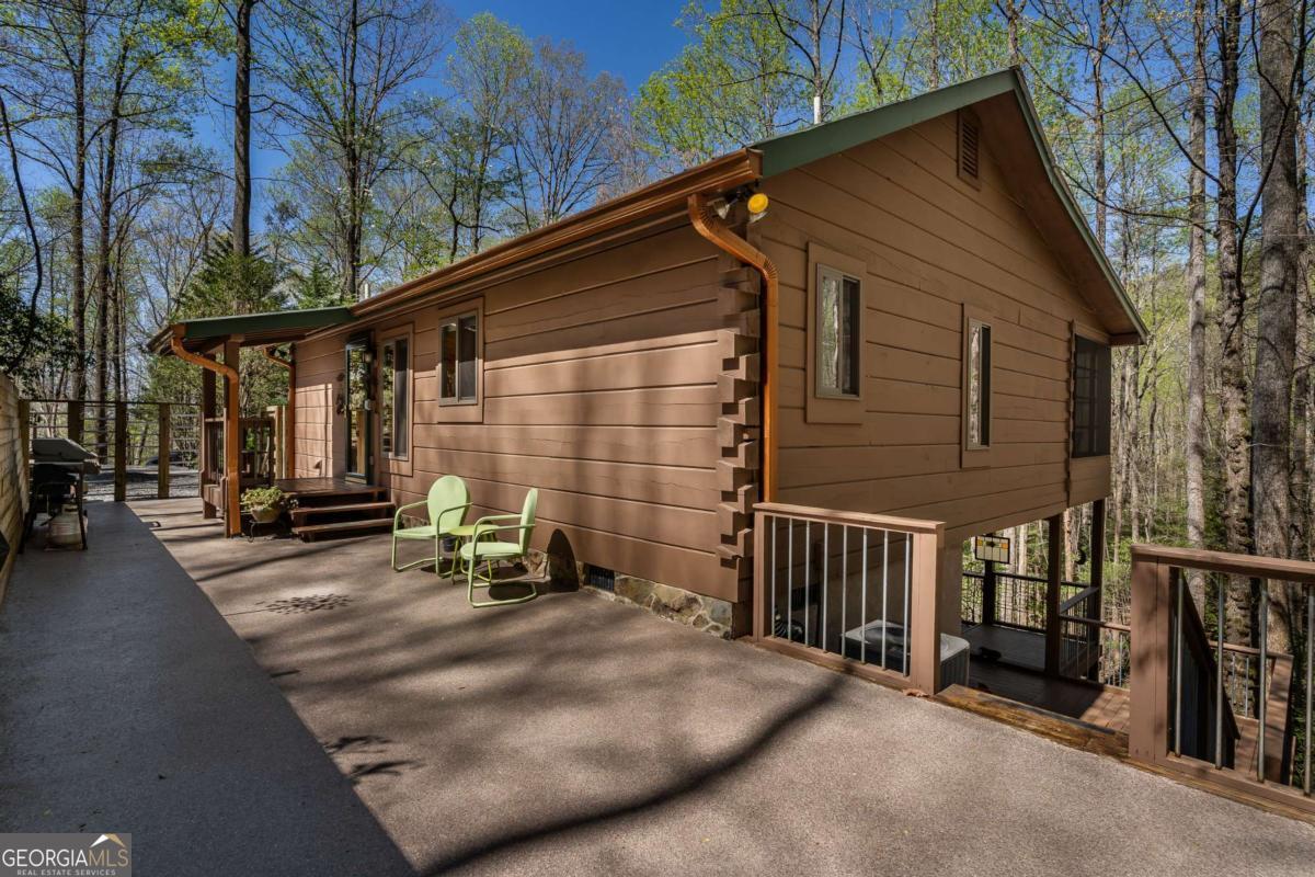 You'll love this pristine, well-cared-for cabin in the beautiful Cherry Lake community with easy access to Blue Ridge, Ellijay, and all amenities. Enjoy the clean mountain air and tranquility of this 2.51 acre property nestled amongst beautiful hardwoods, mountain flora, and wildlife! The driveway offers generous parking leading up to a three step entry. Such a welcoming cozy home with a great central gathering area in the well appointed kitchen (stainless appliances), dining area, and great room with a wood burning fireplace for chilly mountain evenings. Each well sized bedroom is located on opposite sides of the home and includes an en-suite bathroom. From the great room, journey out to the large sun room where you can take in the beauty of the surroundings, read a book, have a nice glass of wine, or your first cup of coffee in the morning! Made especially for all seasons, the sun room windows help to keep you cozy during the winter or you can open the windows and use the installed screens to catch cool breezes in the summer. Enjoy entertaining? This home provides great guest flow from the main home out to the sunroom and the multiple outdoor living spaces. The owners recently installed Anderson Windows for upgraded style and energy efficiency. Step down to another outdoor covered porch with plenty of space for dining and entertaining. Don't miss the workshop (behind the colorful door) along with a storage room including a door that leads you into the best crawl space ever as it's been converted into tons of additional storage! This home is located in a stunning environment and would be perfect for full-time living, vacation home, or vacation rental in a very popular community! The mountains are calling and you won't be disappointed!