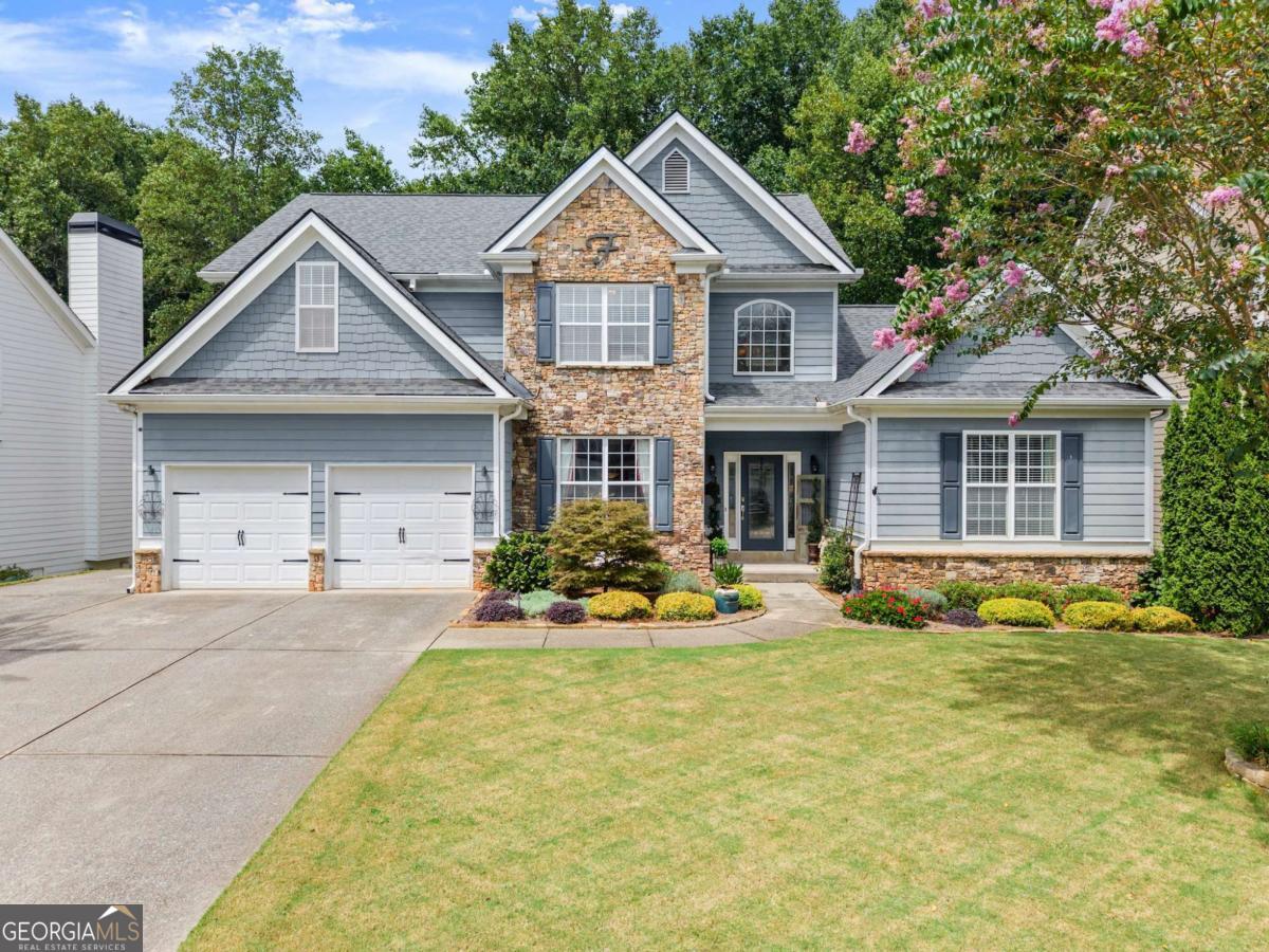 Welcome to your dream home, where timeless design and resort-inspired living converge in one of Forsyth County's most coveted communities. Set within Hampton Golf Village-home to championship golf, tennis, and swim amenities-this residence isn't just a home, it's a sanctuary where elegance meets everyday ease. From the moment you step inside, sunlight pours through soaring two-story living spaces, and a dramatic double-sided fireplace grounds the open flow with warmth and sophistication. A vaulted office offers quiet inspiration, while the open kitchen, keeping room, breakfast nook, and formal dining room make this home a natural stage for grand gatherings and holiday traditions. The main-level primary suite feels like a private retreat, framed by a deep tray ceiling, custom dual closets, and a newly refreshed bathroom. Upstairs features three gracious bedrooms and two full bathrooms, all with tremendous storage and walk-in closets. The rare, fully finished basement extends the possibilities with a true in-law suite, complete with a full kitchen, two bedrooms, a workshop space, and storage galore-perfect for multigenerational living, long-term guests, or simply reimagining your lifestyle with flexibility. Outdoors, a peaceful backyard oasis awaits. Professionally landscaped gardens, subtle yet luxurious low-voltage lighting, and the soothing presence of a koi pond create a retreat that transforms with the setting sun. Here, twilight becomes a private show, and evenings with family and friends feel like a getaway without leaving home. All of this is enhanced by Forsyth County's award-winning schools, vibrant community, and proximity to Lake Lanier, GA wine country, and Atlanta-bringing nature, luxury, and connection into your daily rhythm. Don't miss the Forsyth County Library within walking distance to the house! This is more than a residence; it is a canvas for celebrations, serenity, and a life well lived.