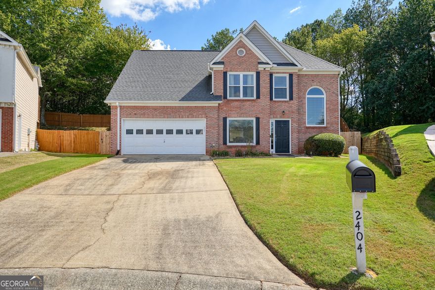 Smart Home enabled and Furnishings Optional!! Nestled at the end of a quiet cul-de-sac in one of East Cobb's most sought-after enclaves, this timeless 2 story brick front traditional home embodies both comfort and refinement. Surrounded by lush, professionally landscaped grounds, the property offers serene privacy while remaining moments from top-rated Cobb County schools, boutique shopping, and upscale dining. Step inside to discover a warm and inviting main level adorned with gleaming hardwood floors and architectural details throughout. The 2 story family room serves as the heart of the home, where a gas log fireplace and soaring windows create an ambiance of light and sophistication. Overlooking this beautiful space is a gourmet kitchen featuring polished granite countertops, breakfast bar, nearly new high-end stainless steel appliances, and a breakfast area perfect for casual gatherings. The luxurious primary suite is a private retreat with elegant double tray ceilings and dual walk-in closets. Its spa-inspired bath boasts ceramic tile flooring, a soaking garden tub, separate shower, and dual vanities-an ideal haven for relaxation. Modern convenience meets peace of mind with advanced smart home features including a smart thermostat, security system with cameras, electronic keypad locks, smart garage door openers and full remote access control. A whole-home backup generator valued at $15,000 ensures uninterrupted comfort during any season. Completing this turn-key offering, most furnishings are optional and appliances including a deluxe water softener system and front-load washer and dryer are included at no additional cost to the buyer. Blending traditional architecture with today's technology and effortless livability, this East Cobb gem presents a rare opportunity to own a fully equipped home in one of metro Atlanta's most prestigious communities.