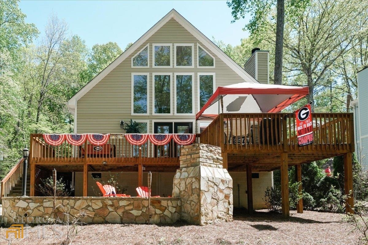 This lake home is a wonderful opportunity for anyone looking for a turn-key 2nd home or primary residence on Lake Lanier. The modified a-frame design, along with the renovated kitchen and bathrooms, add character and charm to the home, while the prime location on the water and proximity to shopping and dining make it convenient for day-to-day living. The deep water lot and recently re-boarded party deck offer ample opportunity for outdoor activities and entertainment, while the updated appliances and quartz countertops throughout provide modern convenience and style. The huge primary suite with ensuite bathroom and walk-in closet is sure to provide a comfortable and luxurious living space, while the open concept and soaring ceilings in the great room add to the spaciousness and natural light of the home. The wood burning fireplace in the great room is also a lovely feature for cozy evenings indoors. The outdoor oasis with deck overlooking the lake and flagstone patio with outdoor fireplace is sure to be a favorite spot for entertaining and relaxation, and the new carpet and paint add to the overall freshness and move-in readiness of the home. With all these features and amenities, this lake home is indeed the perfect lake home at the perfect price, and an excellent opportunity for anyone seeking a comfortable and convenient waterfront living experience.