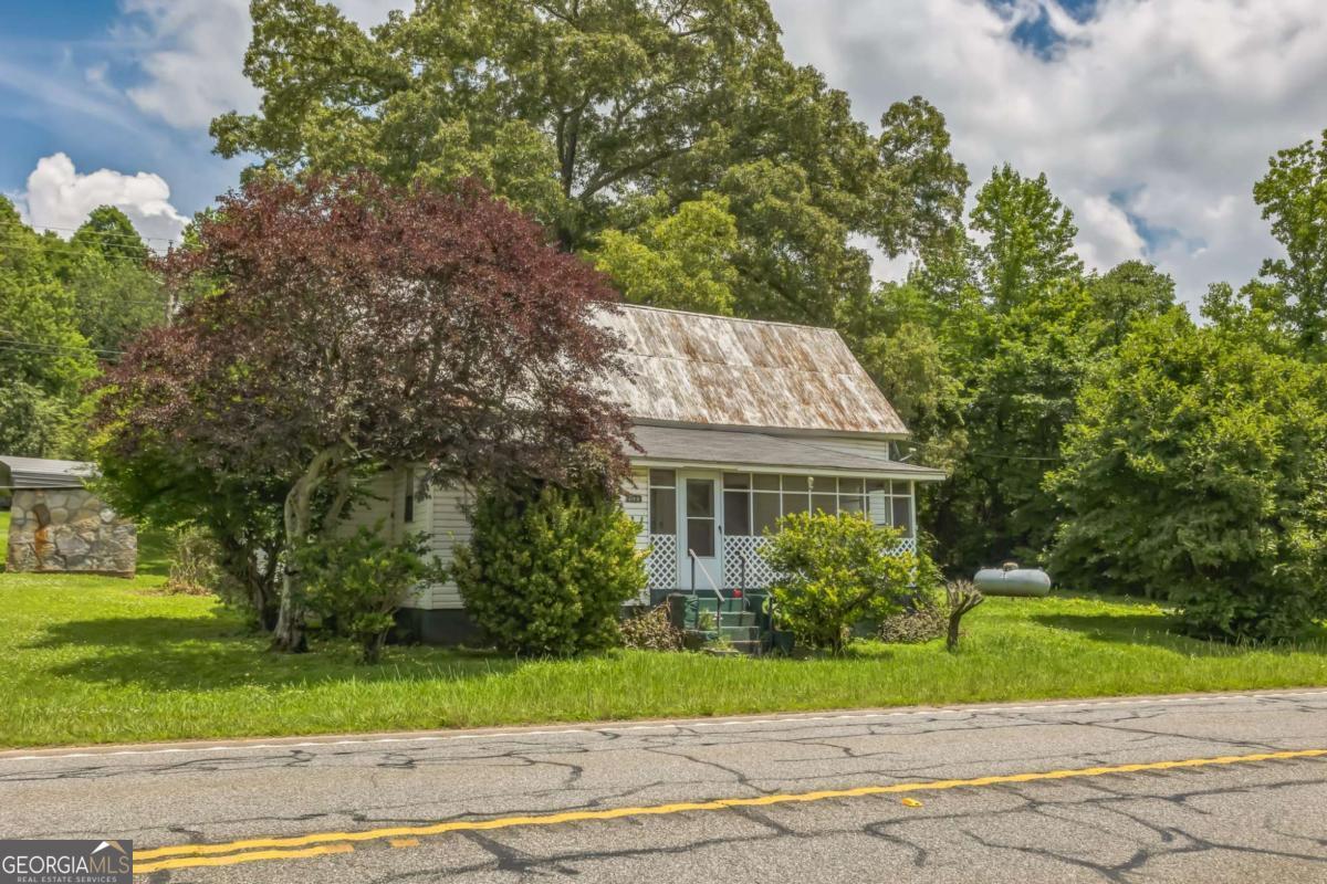 Step into a slice of North Georgia history with this 3-bedroom, 1-bath farmhouse. Built in 1900, this 1,340 sq ft home blends vintage charm with great bones, offering a rare opportunity for customization, renovation, or investment. Single-level ranch home with screened-in front porch perfect for relaxing with a morning coffee or winding down with evening breezes. The layout includes a cozy living area, ample cabinet space in the kitchen, and three comfortably sized bedrooms ready for your personal touch. Located off Hwy 411, you're approximately 30 minutes from Calhoun, Cartersville, Chatsworth, Dalton, Ellijay, Jasper, offering the perfect balance of rural charm with nearby conveniences. Perfect opportunity for DIY enthusiast, investor, or someone dreaming of life on a quiet lot, this home is your canvas to create something truly special.