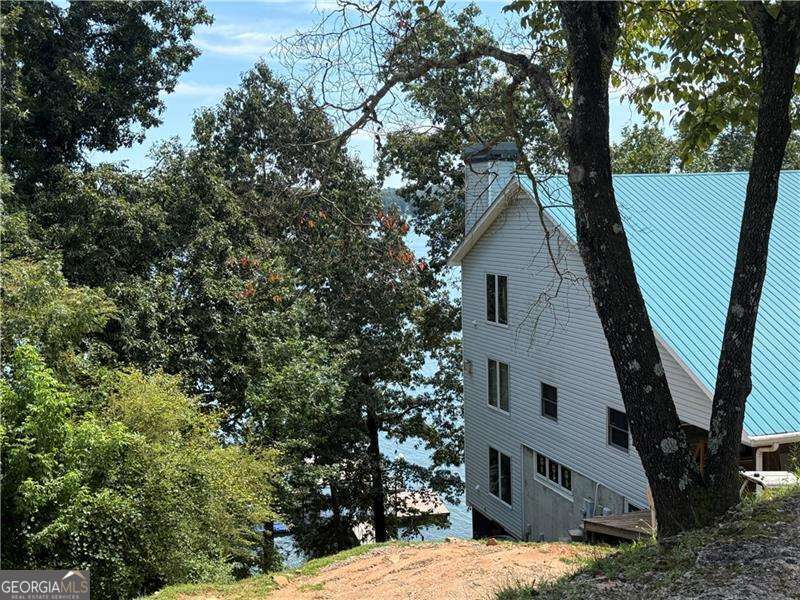 Breath taking views of Lake Lanier with gorgeous sunsets. You can sit on one of the decks or on the doc and watch the boats go by and the sun set. This is a large house that is waiting for someone to come and and finish it to make it their dream home. All the hard work is done and a buyer can do all the finishes. You will have a gem on Lake Lanier when it is all done! Lifetime water heater, galvanized steel roof, great doc, outside decks, fire pit.