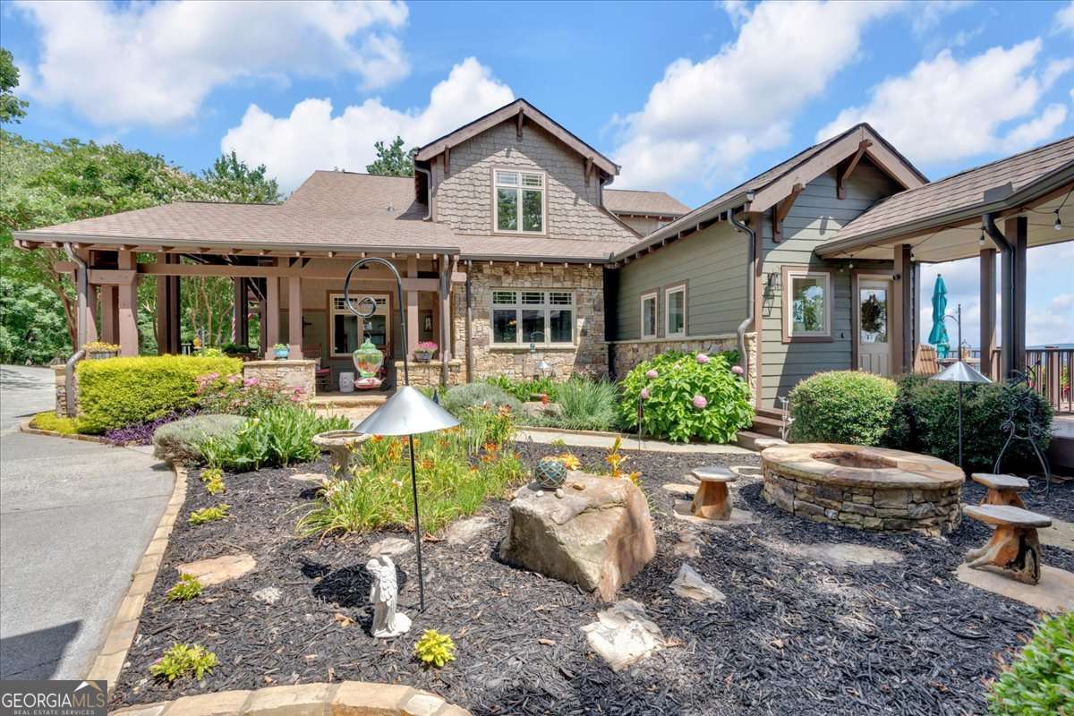 Experience elevated mountain living in this breathtaking Craftsman-style home, offering PANORAMIC views from every level. With THREE expansive decks, each floor seamlessly blends indoor and outdoor living. The updated kitchen is a showstopper with freshly painted cabinetry, new hardware, stunning ceiling-height tile backsplash, wood beams, open shelving, and beautiful new countertops. A custom walk-in pantry provides ample storage with built-in cabinetry and shelving. The kitchen opens to a breakfast area with direct access to a view-filled deck, and a formal dining room featuring elegant coffered ceilings. The MAIN-LEVEL living room is highlighted by a floor-to-ceiling stone fireplace with gas logs and framed by picture windows showcasing the SCENIC backdrop. The owner's suite is also on the main level, offering mountain views and a luxurious en-suite with HEATED tile floors throughout the bathroom and California closet, a freestanding soaking tub with views of the mountains, tile shower, and custom vanity with generous storage. A private office with custom wood-paneled walls and built-ins, plus a mudroom and laundry area off the side entry, complete the main level. UPSTAIRS, a cozy loft offers mountain and seasonal water views. Two guest bedrooms each feature private, updated en-suite baths. The LOWER LEVEL includes a fourth bedroom with views and deck access, an additional updated full bath, a spacious den with a dramatic wall-to-wall stone fireplace, a game room with wet bar, a gym, and a media room that can serve as a fifth bedroom. Two oversized storage rooms provide abundant space for seasonal decor and more. This BEAUTIFULLY landscaped home is part of a DESIRABLE community with access to a pool, tennis courts, and clubhouse-perfect for those seeking LUXURY, COMFORT, and VIEWS at every turn-and it's less than 5 minutes from I-75 and approximately 10 minutes to the Park Marina, Allatoona Beach, Lakepoint Station, and Red Top Mountain State Park. The home is also equipped with a whole-house generator, providing peace of mind during power outages. DON'T MISS your chance to tour this beautifully remodeled home-featuring stunning updates throughout, including the kitchen, bathrooms, closets, mudroom, shiplap walls, and so much more. Come see it for yourself and fall in love with all the fresh, modern touches! (The seller also has a boat with an assigned slip at Park Marina available for purchase separately. This could be an incredible added bonus to complement the home. Additional details are available upon request)