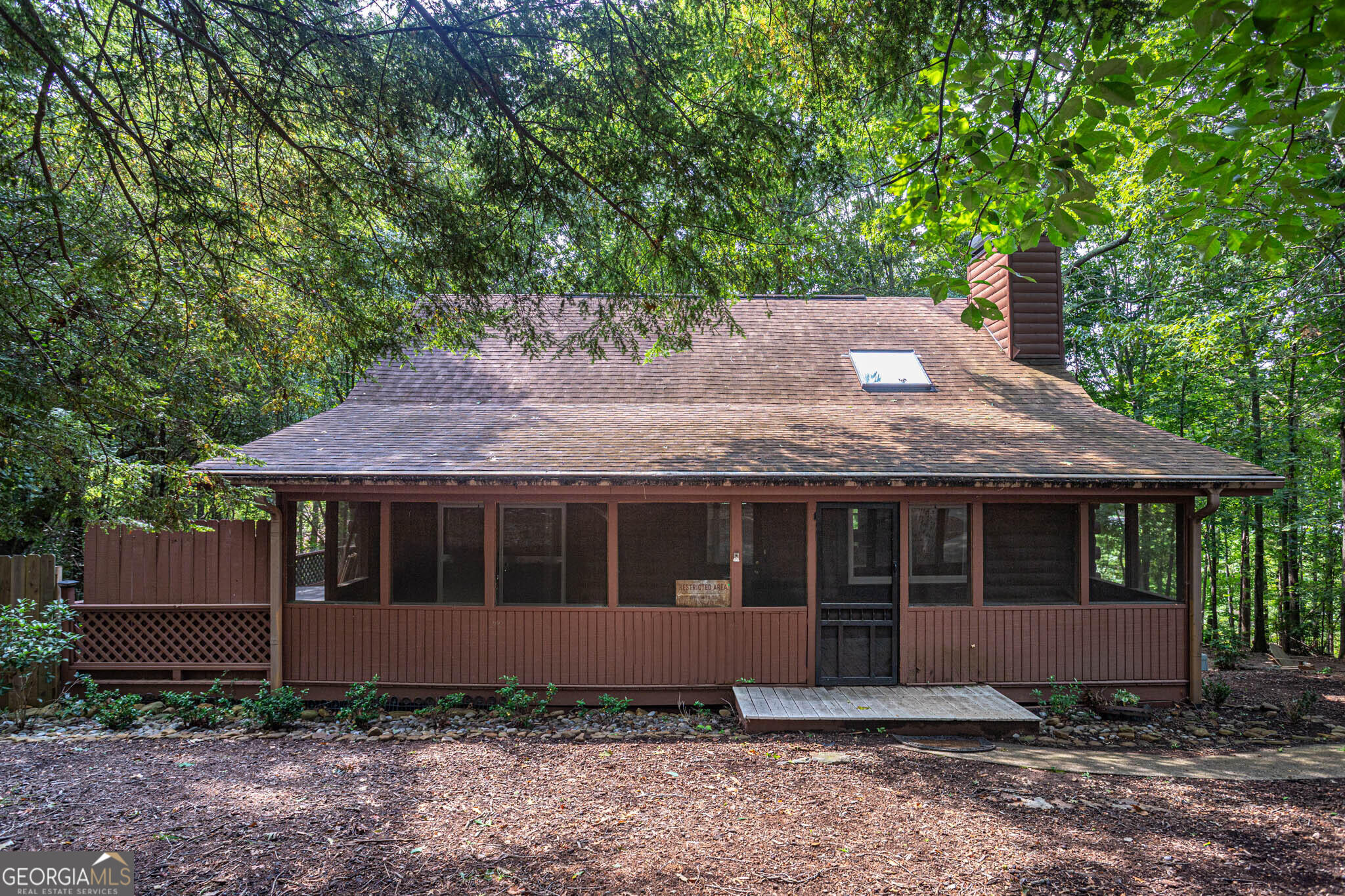 This Lake Lanier property offers exceptional versatility with a mother-in-law suite, and a finished basement complete with a kitchenette. Located in Hall County, just 150 feet from the county line for lower taxes!! The home provides central access to Lake Lanier with a private cove and Port Royale conveniently. Easy access to Browns Bridge Road! The residence has been thoughtfully updated with two new 55-gallon water heaters, a new carport, and high-end double-pane sound-absorbing windows installed in 2024. Additional features include hardwood floors, a screened front porch, and abundant natural light. The exterior showcases new landscaping, a large fenced-in backyard, and a deck with a built-in hot tub purchased in 2022. The 0.69-acre wooded lot offers a natural setting where wildlife frequently passes through while remaining outside the fenced area. The single street has a cul-de-sac for added privacy, and the absence of an HOA enhances flexibility. With its combination of lake access, desirable location near parks, shopping, and restaurants, and strong potential for rental or Airbnb income. Or just rent the basement and live on the main levels. This property presents a rare opportunity on Lake Lanier.