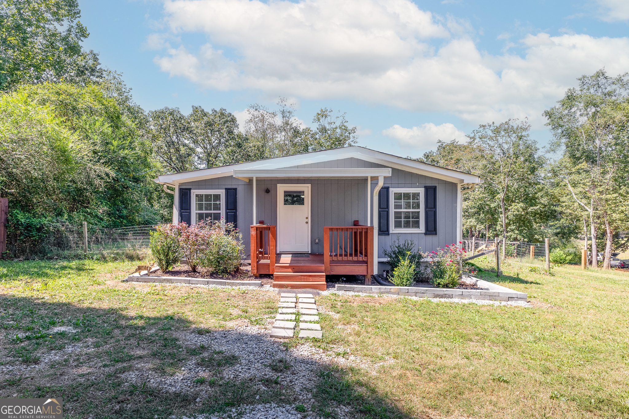 Charming two bedroom, two full bathroom cottage, combining character with modern updates. Originally built in 1930, this home was completely gutted to the studs in 2020 and remodeled, giving you peace of mind with modern systems and updates while still retaining its cottage charm. Enjoy your mornings on the front porch, relax on the back porch, or take advantage of the partially fenced yard with plenty of room to garden, play, or simply unwind. Sitting on a spacious 1.14-acre level lot, this home is move-in ready and waiting for its next owner. Step inside to find an open, light-filled layout with kitchen featuring granite countertops - perfect for everyday living. Need storage? You'll love the oversized 14'x28' shed, ideal for tools, hobbies, or even a workshop. Located in a quiet setting yet still convenient to Gainesville's shopping, dining, and Lake Lanier, this property blends comfort, charm, and practicality - all on a beautiful acre-plus lot. Move right in and start enjoying your own piece of Gainesville!