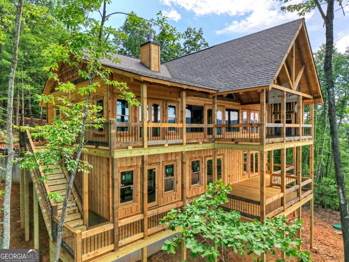 BRAND NEW QUALITY CONSTRUCTION in BEAUTIFUL "MOUNTAIN HIGH" (Gated & Paved Community). BEST LONG RANGE MULTI-LAYERED MOUNTAIN VIEW on the Market.... Sweeping from North Carolina, Georgia & into Tennessee. 4-BDRM Rustic Ranch w/ONE LEVEL Easy Living. Great Rm & Dining Rm separated by a TWO-SIDED ROCK Fireplace. Dormer Windows light up the Well-Appointed Kitchen & Dining Area. GREAT RM GLASS WALL to a Huge OPEN GABLE Party Porch w/Exterior Fireplace with Sweeping Views in all Directions. Huge Custom Kitchen w/Counter Bar overlooking Dining Room Area w/Fireplace. Main Level MASTER Suite w/Double Vanity & Big Tile Shower, Walk In Closet (direct access to Porch from Master). Full Laundry Rm (Laundry Sink/Granite) & Guest Half Bath finish out Main Level. Finished Terrace Level w/Wet Bar, Bonus Family Rm w/Fireplace, THREE Guest Rooms & TWO full baths (Another Master Suite on Terrace Level). Granite Countertops, Ceramic Tile Showers, Custom Cabinets, Wrought Iron Pickets & Oil Rubbed Bronze Custom Light Fixtures. Lots of Fixed Glass Windows, Attractive Wood Textures & Impressive Contrasting Stain Color Combinations (Wainscoting, Accent Walls & Trim). Zoned HVAC. Exterior Staircase connects the Main Level wrap around porch to Terrace Level Porch. Wired for Hot Tub. Vacation Rentals OK. Perfect for Full or Part Time Living & FANTASTIC Vacation Rental Potential. Very Supportive High End Neighborhood. Builder's One Year Warranty. Under Construction, Mechanicals going in now.