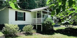 This well-maintained 2004 3-bedroom, 2-bathroom home is situated in a Lake Sinclair neighborhood, offering convenient lake access just minutes away. It is nestled on a private 1/2-acre lot with mature landscaping and a detached two-car garage. This spacious split floor plan features a large living room and an open kitchen with island. There is a cozy sunroom off the master bedroom. The master suite also includes a beautifully remodeled bath, creating a perfect private retreat. Enjoy peaceful surroundings, outdoor space, and the best of lake living, all conveniently located to Milledgeville, Eatonton, and Macon. Listed at just $192,000 and move-in ready, this one won't last long. Schedule your private viewing today.
