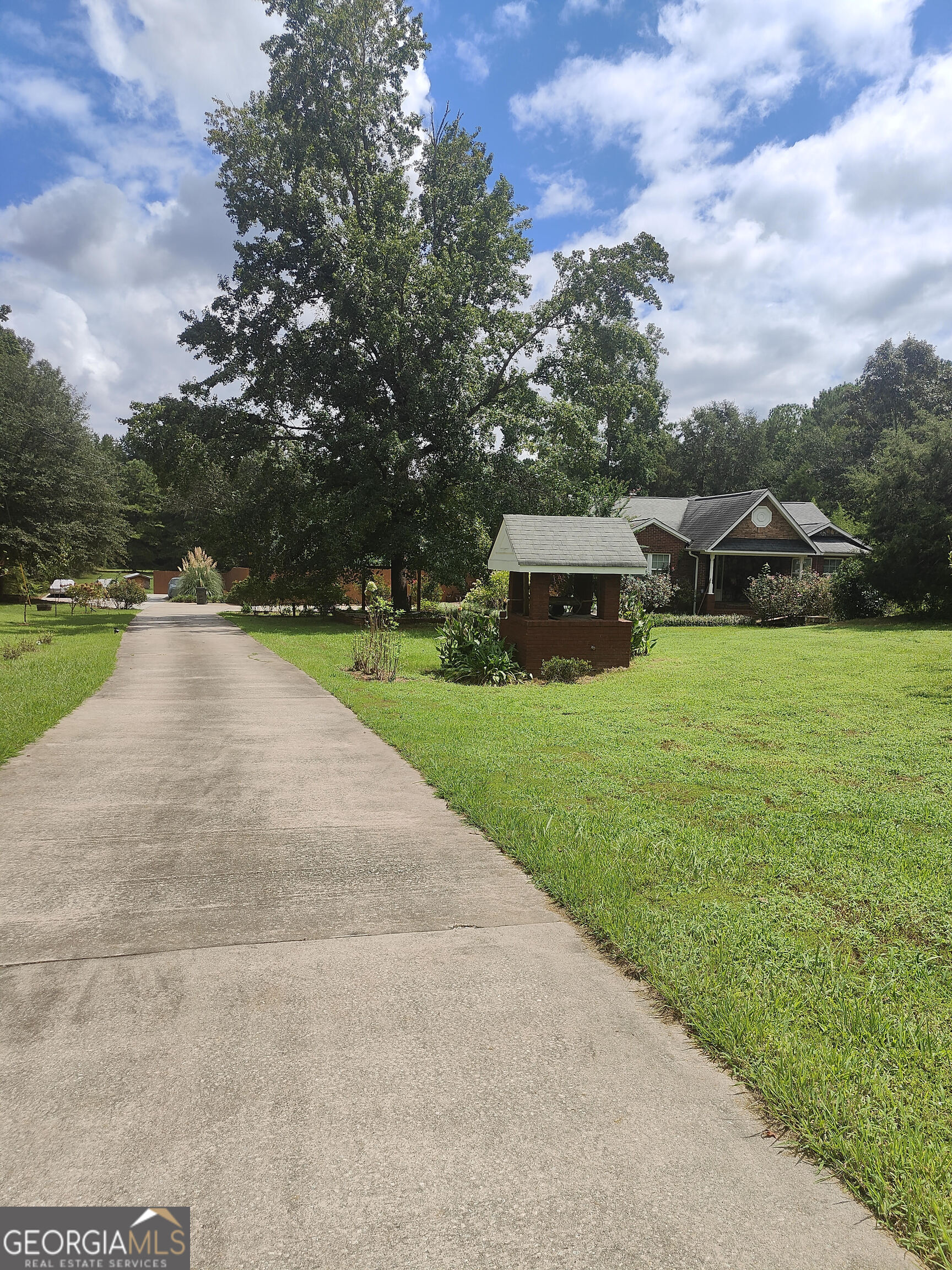 Discover your private retreat on 6.2 beautifully landscaped acres in Spalding County. Nestled in a quiet area of Griffin, yet close to shopping, schools, and major routes. This spacious estate blends comfort, functionality, and outdoor luxury-perfect for multi-generational living, entertaining, or simply enjoying the peace of country life; Two master suites, each with private en-suite baths; Large family room ideal for gatherings and relaxation; Half bath for guests and convenience; Deck with jacuzzi, perfect for unwinding under the stars; Extended driveway with parking for 12+ vehicles; Fruit trees and manicured lawn, offering beauty and bounty; Privacy and space with room to expand or garden.