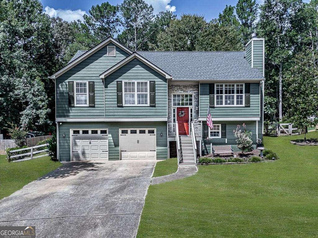 Comfort meets convenience in the sought-after 4 bed 3 bath home in Westwind subdivision of Ball Ground GA. This neighborhood offers large lots, beautiful yards, and an irreplaceable sense of safety. Districted for Creekview High School, children of all ages will love the community!    Upon arriving you'll love the large but low maintenance front yard, fresh paint, and brand-new roof (with 10-year transferrable warranty!) The new fence gate opens to a huge back yard that offers a newly sodded green space, a mulched play area for the kids, and a relaxing fire pit situated in the shade of the mature trees! Freshly painted deck and blueberry bushes thrive along your fence line. Zinnias and marigolds attract butterflies all Spring and Summer long. A recently installed drainage system guarantees peace of mind during rainy weather.    Inside you'll find 4 bedrooms and 3 FULL bathrooms: All freshly painted. Upstairs, the kitchen and living room welcome you with large East/West facing windows showcasing incredible sunsets over the lake behind your property. Brand new bamboo blinds maintain your privacy while allowing light to filter through. The kitchen is the perfect size with lots of cabinets, and all-new Whirlpool appliances. Vaulted ceilings soar over the common areas as well as the master bedroom, which has a walk-in closet, private bathroom with his-and-hers sinks, a linen closet and a large bathtub. Down the hall you'll find two secondary bedrooms and a full bathroom. Brand new cordless blinds and fans in each bedroom will keep you cool, and beautiful new light fixtures throughout the house give a modern touch. Recently installed toilets offer a nice clean update to the bathrooms.  Downstairs boasts a second living area, fourth bedroom, third full bathroom, THREE closets, and a full-sized laundry room.    Walk out from the lower level into your huge two-door garage, which features a massive storage area beyond the parking spaces.    Conveniently located near the intersection of 369 and 372, and I-515. this tucked-away home is an easy drive to boutiques, shops and restaurants in Downtown Ball Ground along with Quick access to highway 20 to take you anywhere you want to go!