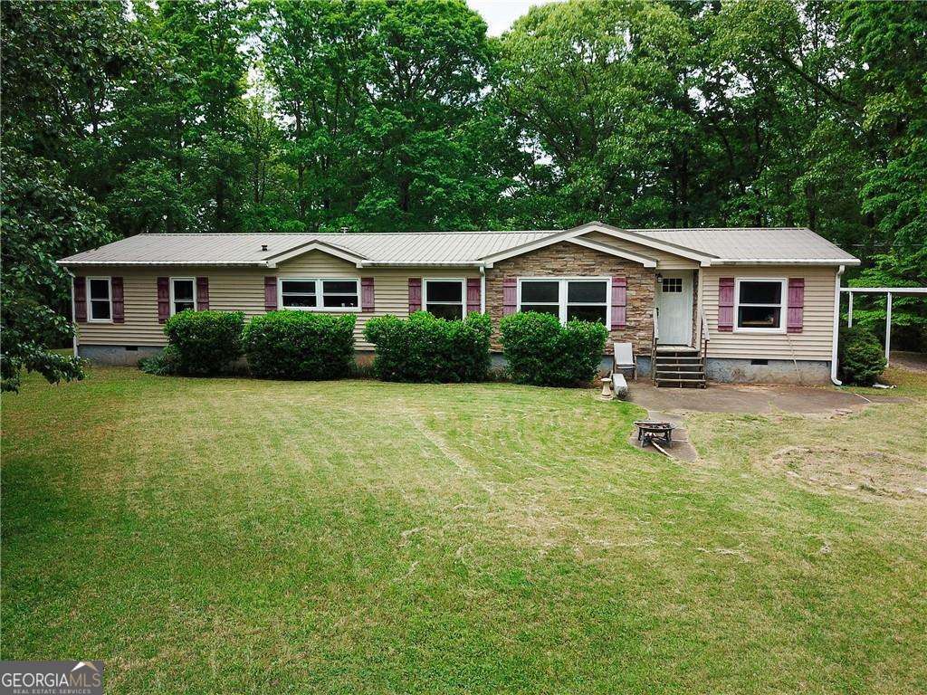 Phenomenal opportunity for 7 acres including a large mobile home with metal roof ! Come build your dream home! Lots of big hardwoods and potential views. Mobile home needs floor covering (carpet/lvp) and some updates. Land is made up of two combined lots. The main lot has driveway to Old Mill Rd but there is also a second easement for additional access as well.